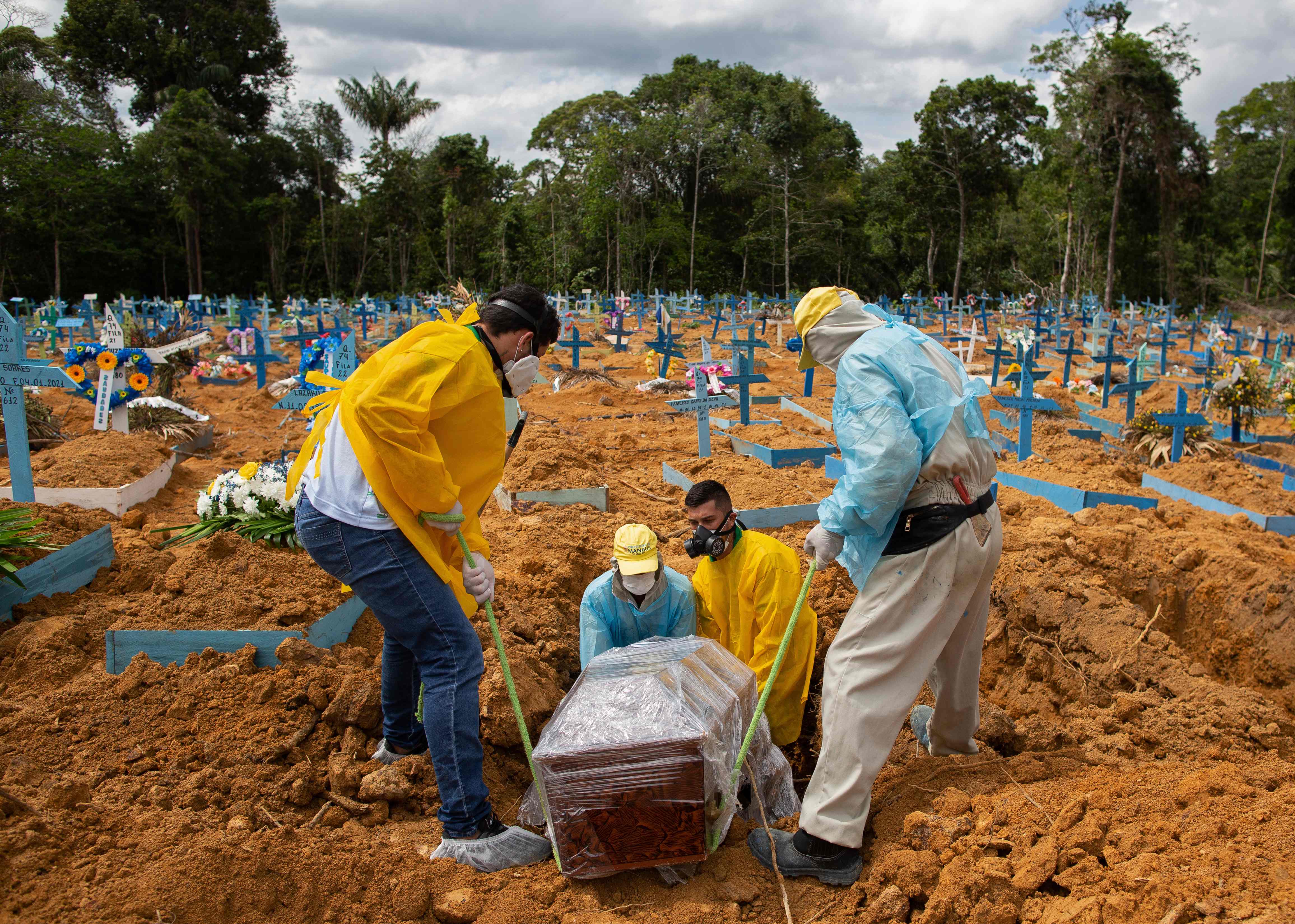A burial takes place in an area reserved for COVID-19 victims at the Nossa Senhora Aparecida cemetery in Manaus, Brazil, on January 5, 2021. (Photo by MICHAEL DANTAS / AFP)