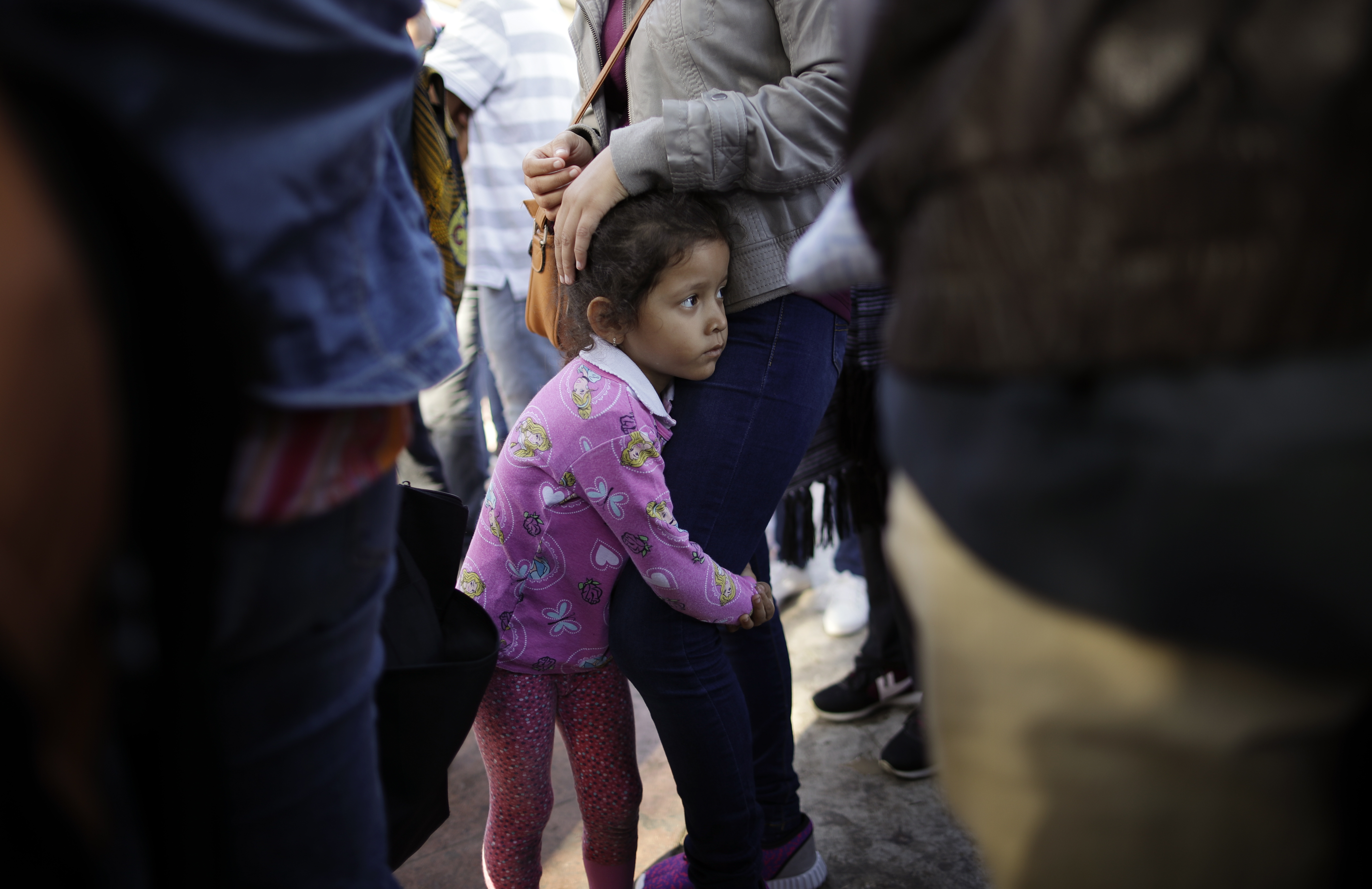 Nicole Hernández se aferra a su madre mientras esperan para pedir asilo político en Estados Unidos, al otro lado de la frontera en Tijuana, México, el miércoles 13 de junio de 2018. La familia ha estado esperando alrededor de una semana en esta ciudad fronteriza con la esperanza de escapar de la violencia en su estado natal, Guerrero.