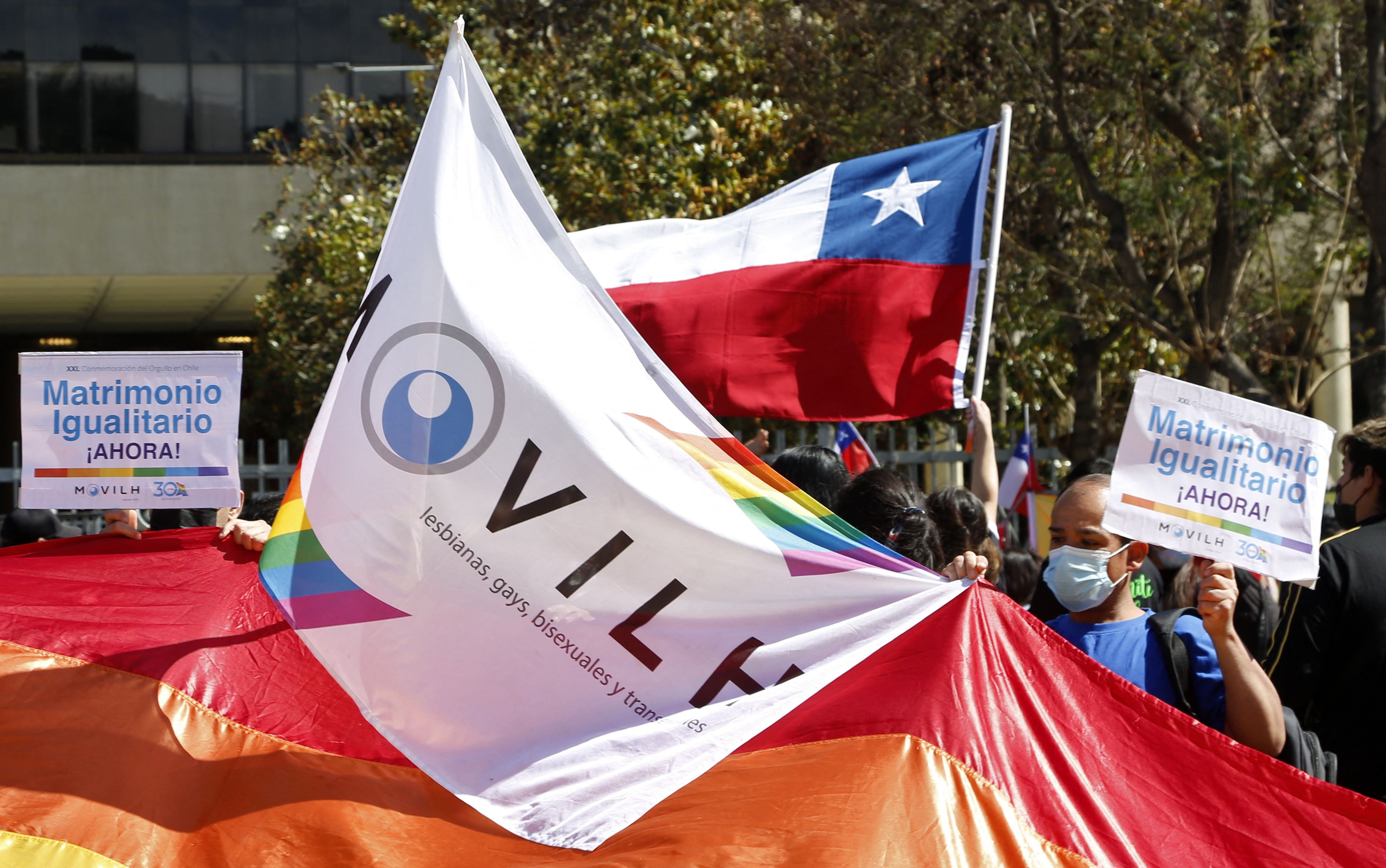 Members of the Homosexual Liberation and Integration Movement (Movilh) hold a vigil outside the National Congress in Valparaiso, Chile, on November 30, 2021, as Chile's parliament is set to approve a long-awaited bill to legalize same-sex marriage. - With the approval, Chile will join just a handful of countries in majority Catholic Latin America with similar laws. The bill will also enable married same-sex couples to adopt children. Chile, which legalized same-sex civil unions in 2015, has been awaiting this bill since 2017, when it was sent to congress by socialist then-president Michelle Bachelet. (Photo by Dedvi MISSENE / AFP)