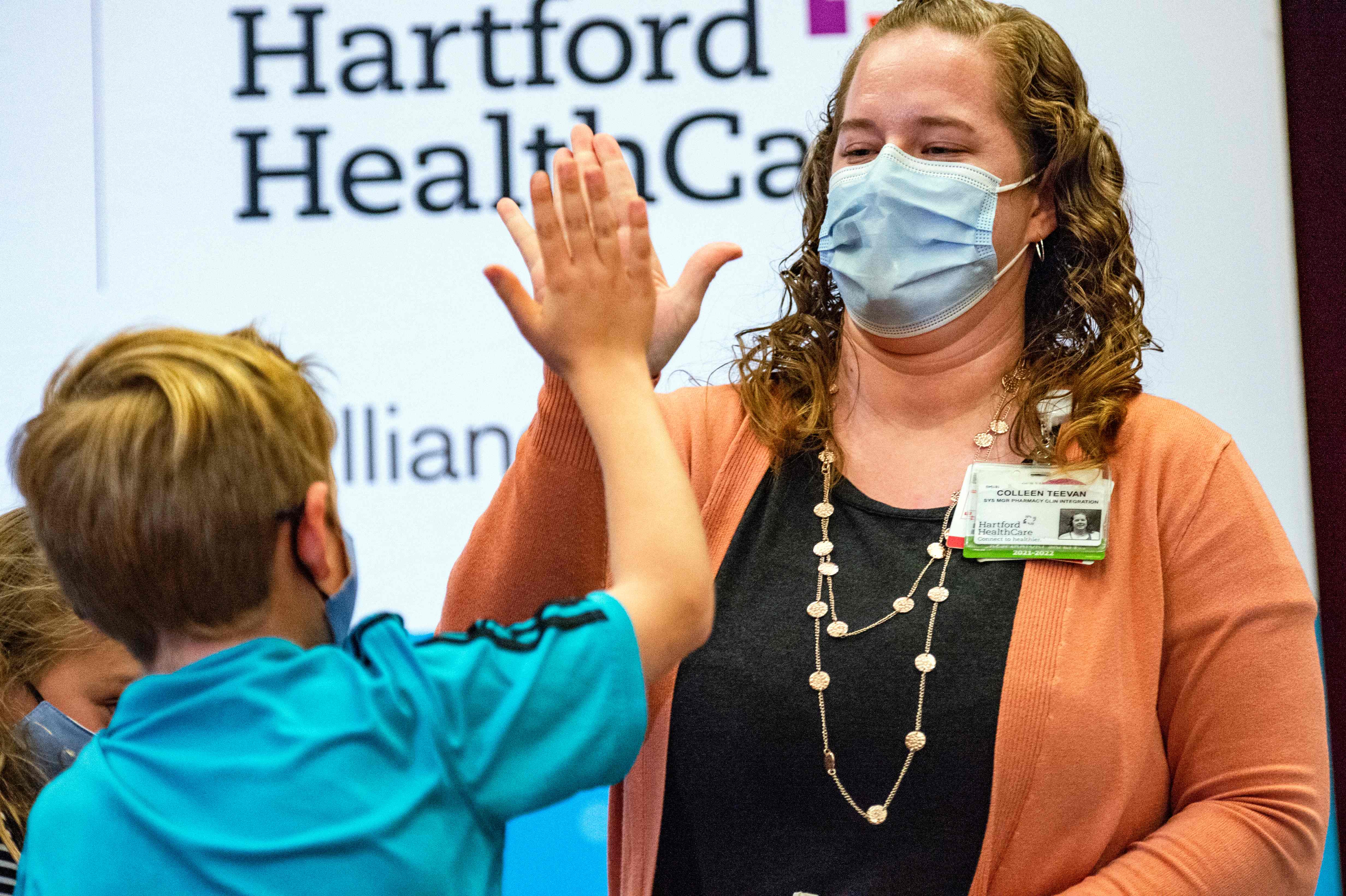 TOPSHOT - A ten year old child high fives Pharmacist Colleen Teevan after he received the Pfizer-BioNTech Covid-19 Vaccine for kids at Hartford Hospital in Hartford, Connecticut on November 2, 2021. - The United States can now start giving children aged 5-11 the Pfizer-BioNtech Covid vaccine, US health authorities said Tuesday in a move hailed by President Joe Biden as a "turning point" in the fight against the pandemic. (Photo by JOSEPH PREZIOSO / AFP)