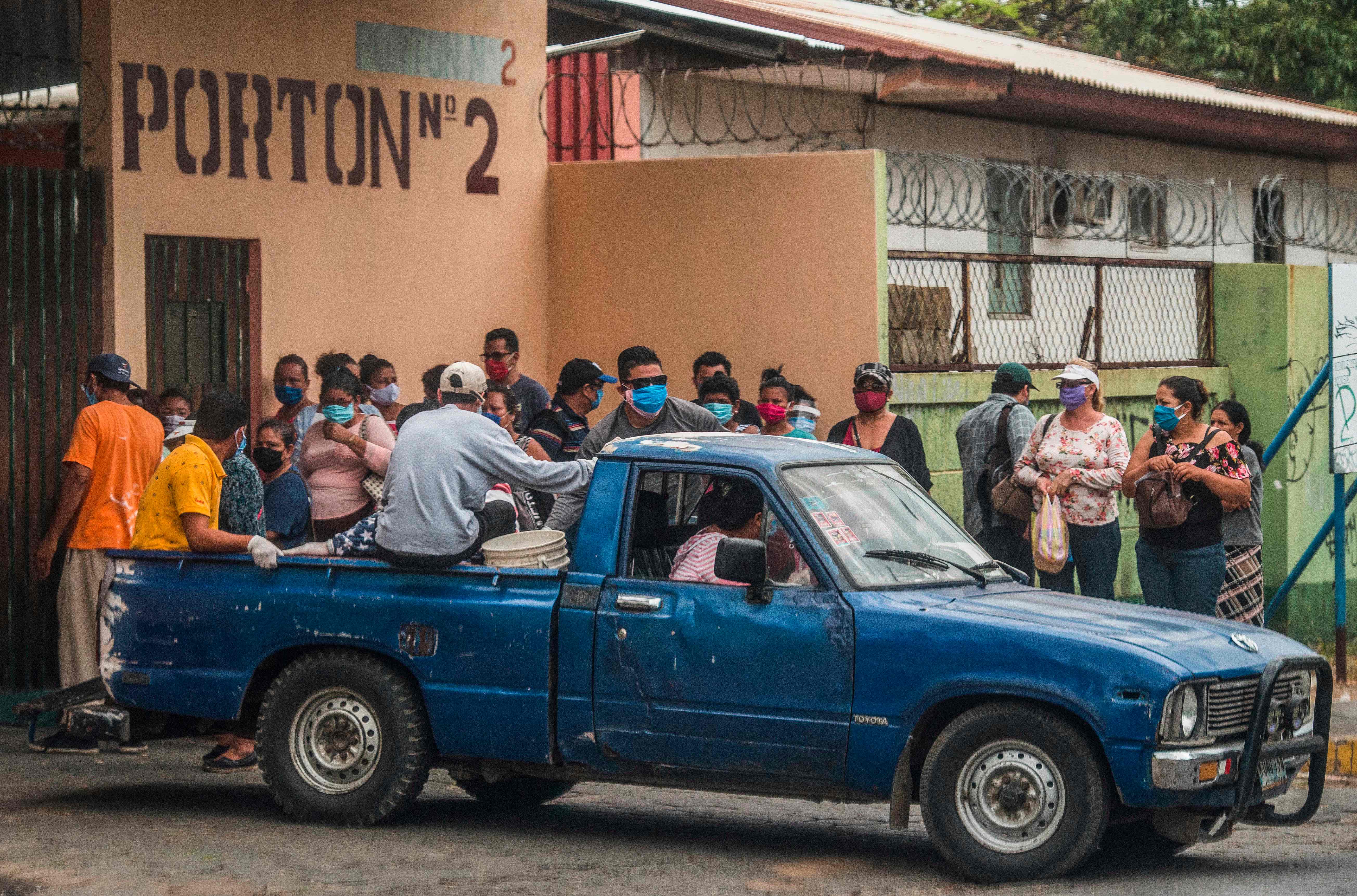 The coffin with the body of a patient who died with symptoms of the new coronavirus, COVID-19, is carried by relatives to be buried outside the German-Nicaraguan Hospital, in Managua on May 13, 2020. (Photo by STR / AFP)