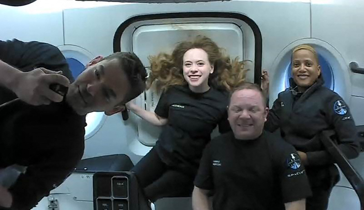 (FILES) In this file photo taken on September 16, 2021 courtesy of Inspiration4 shows the Inspiration4 crew (L-R) Jared Isaacman, Hayley Arceneaux, Christopher Sembroski and Sian Proctor in orbit. - The four private space tourists aboard a SpaceX capsule are due to return to Earth on sEPTEMBER 18, 2021, touching down off the coast of Florida after three days of orbiting the planet. (Photo by Handout / Inspiration4 / AFP) / RESTRICTED TO EDITORIAL USE - MANDATORY CREDIT "AFP PHOTO / Courtesy of Inspiration4" - NO MARKETING - NO ADVERTISING CAMPAIGNS - DISTRIBUTED AS A SERVICE TO CLIENTS