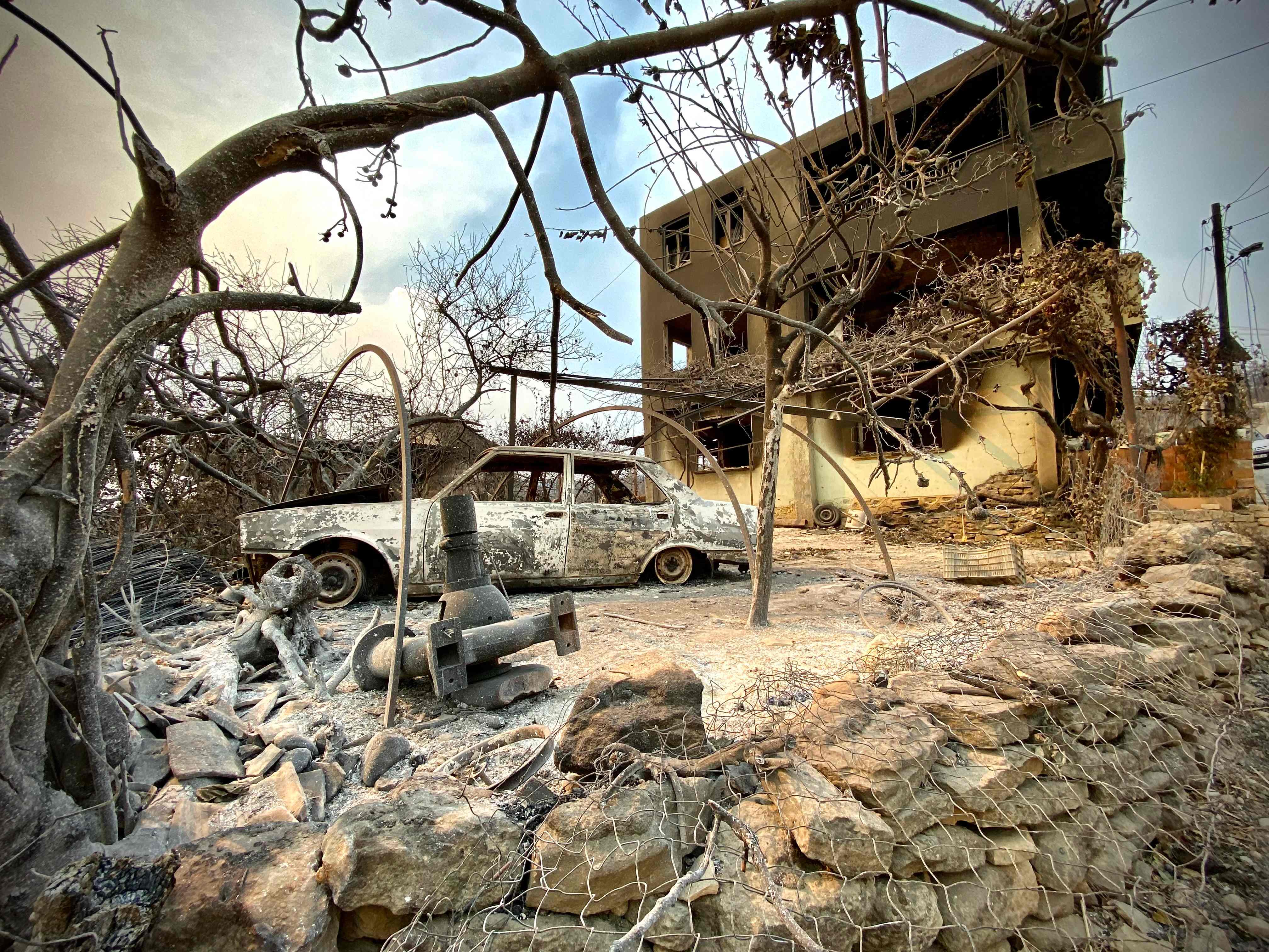 TOPSHOT - This photograph taken on July 31, 2021 near the town of Manavgat shows burnt car in front of a burnt house as a massive forest fire which engulfed a Mediterranean resort region on Turkey's southern coast. - At least three people were reported dead on July 29, 2021 and more than 100 injured as firefighters battled blazes engulfing a Mediterranean resort region on Turkey's southern coast. Officials also launched an investigation into suspicions that the fires that broke out July 28 in four locations to the east of the tourist hotspot Antalya were the result of arson. (Photo by - / AFP)