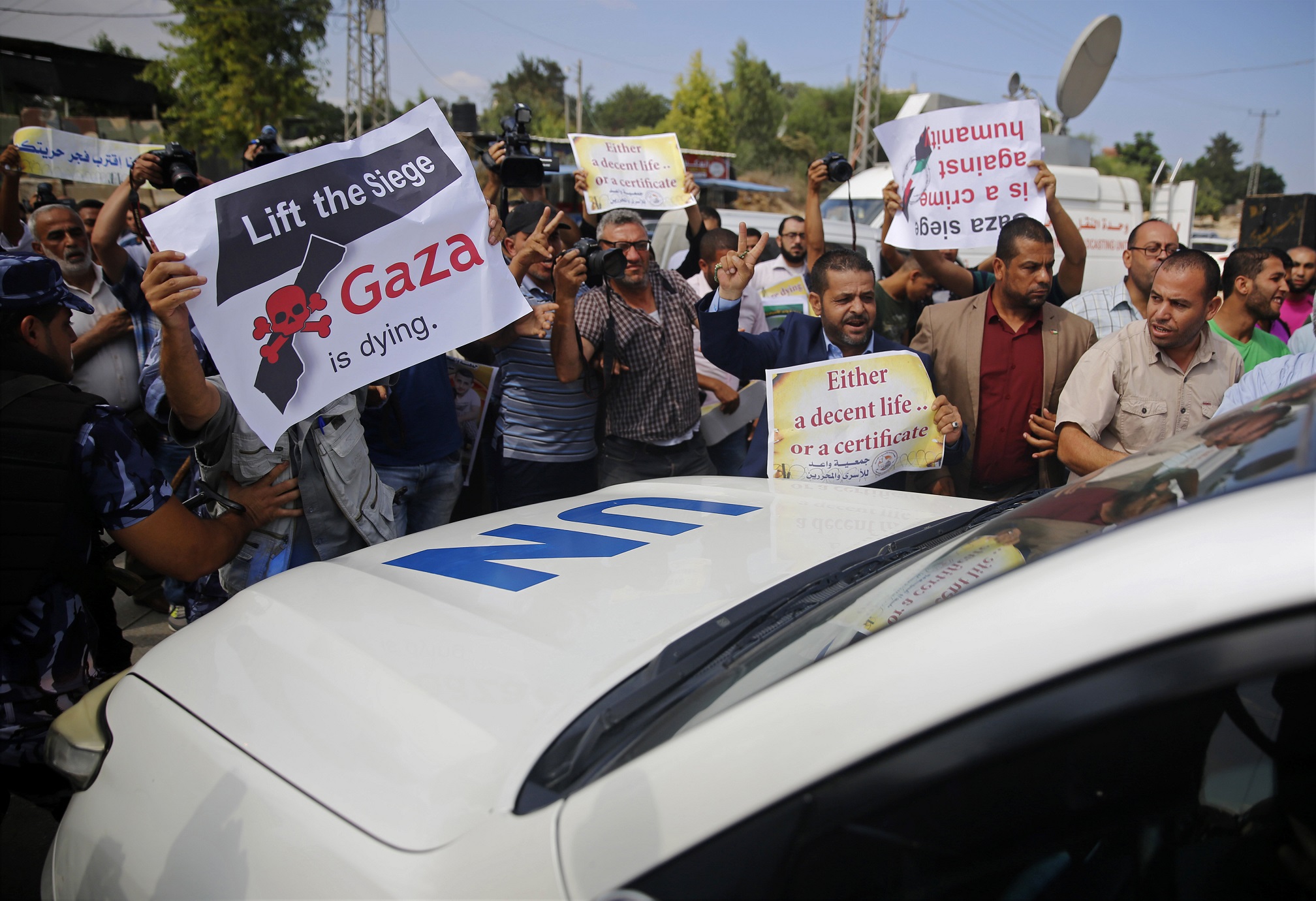 Palestinos gritaban consignas este miércoles 30 de agosto del 2017 mientras bloqueaban el paso de la caravana de vehículos en al cual viajaba el secretario general de la ONU, Antonio Guterres, por la franja de Gaza.