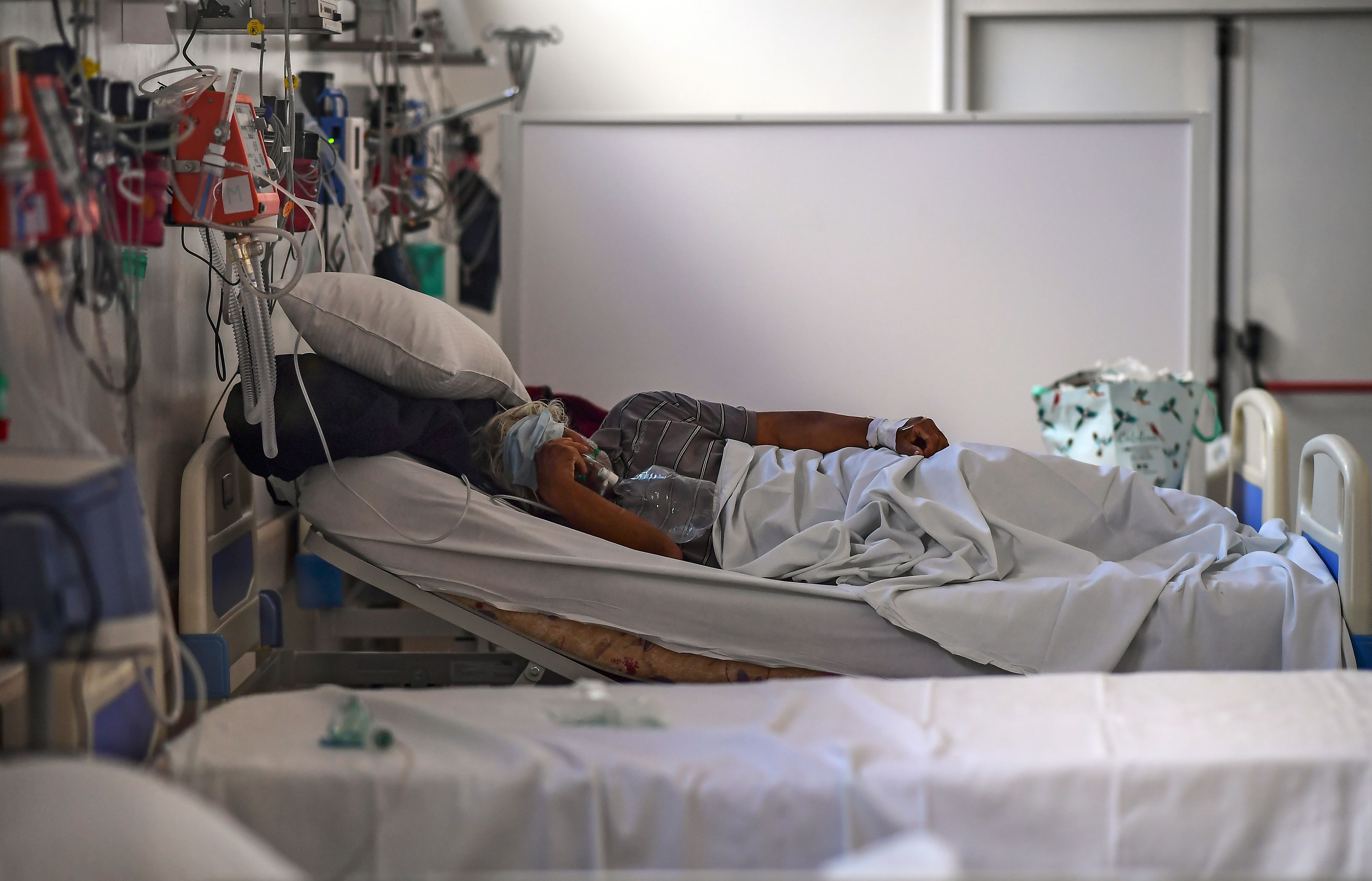 (FILES) In this file photo taken on July 01, 2020 a patient infected with the new coronavirus remains in the Doctor Alberto Antranik Eurnekian Public Hospital in Ezeiza, in the outskirts of Buenos Aires. - Hospitals in the Argentine capital will be instructed to allow family members to maintain a bedside vigil on dying Covid-19 patients, after legislators approved a new law on August 27, 2020. (Photo by RONALDO SCHEMIDT / AFP)
