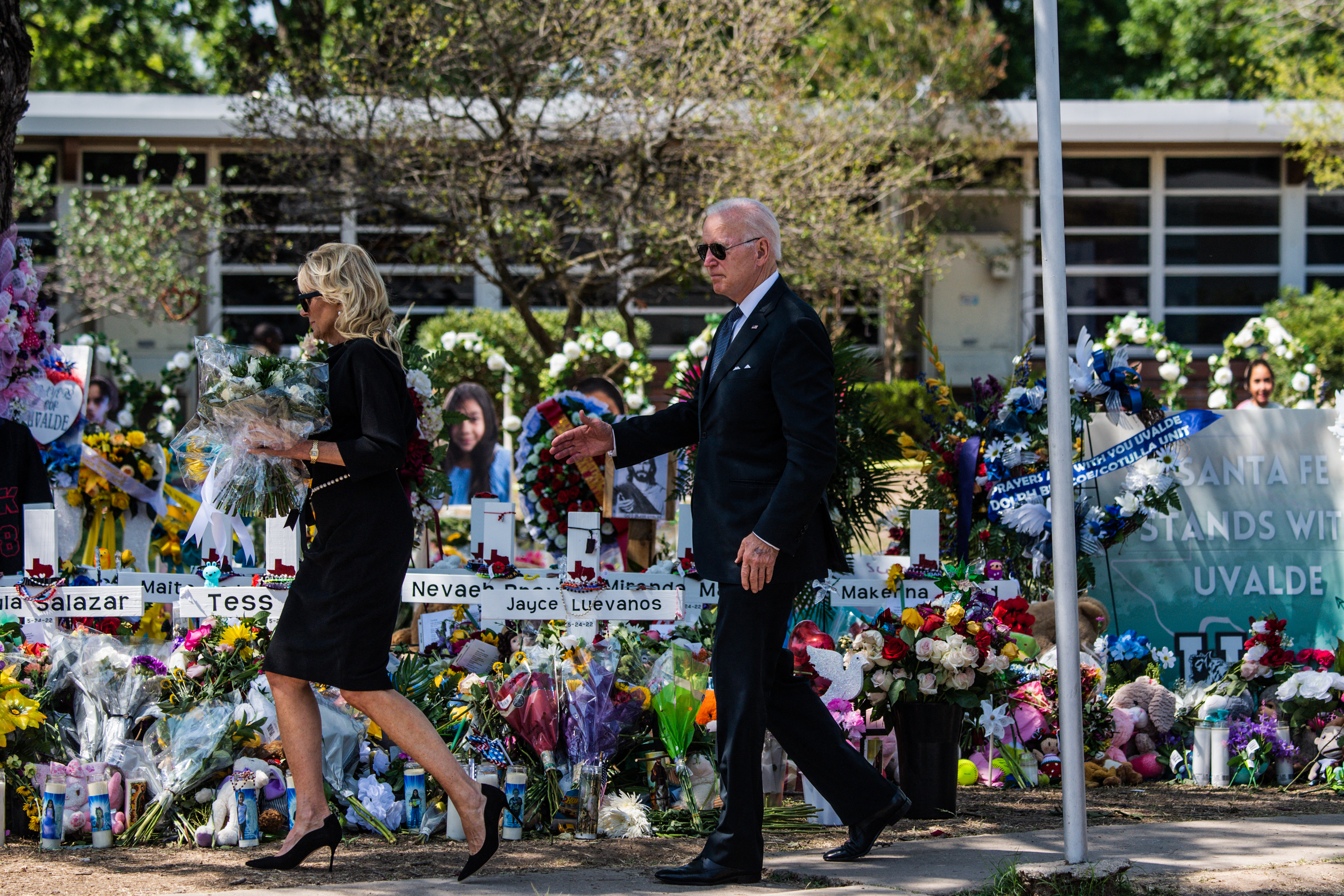 US President Joe Biden and First Lady Jill Biden pay their respects at a makeshift memorial outside of Robb Elementary School in Uvalde, Texas on May 29, 2022. - The President and First Lady are in Uvalde to pay their respects following a school shooting. (Photo by CHANDAN KHANNA / AFP)