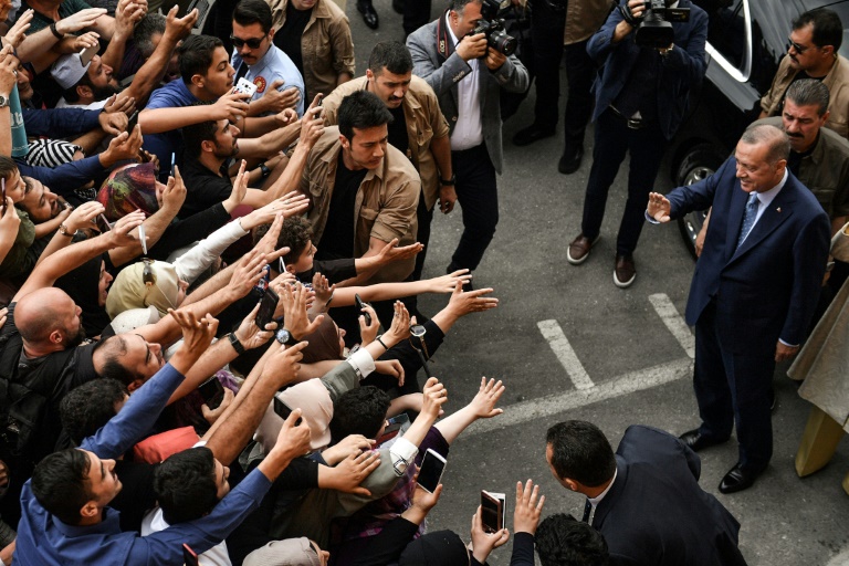 El presidente Recep Tayyip Erdogan saluda a unas personas que se agolpan para tenderle la mano, este domingo 24 de junio a la salida del colegio electoral de Estambul donde votó