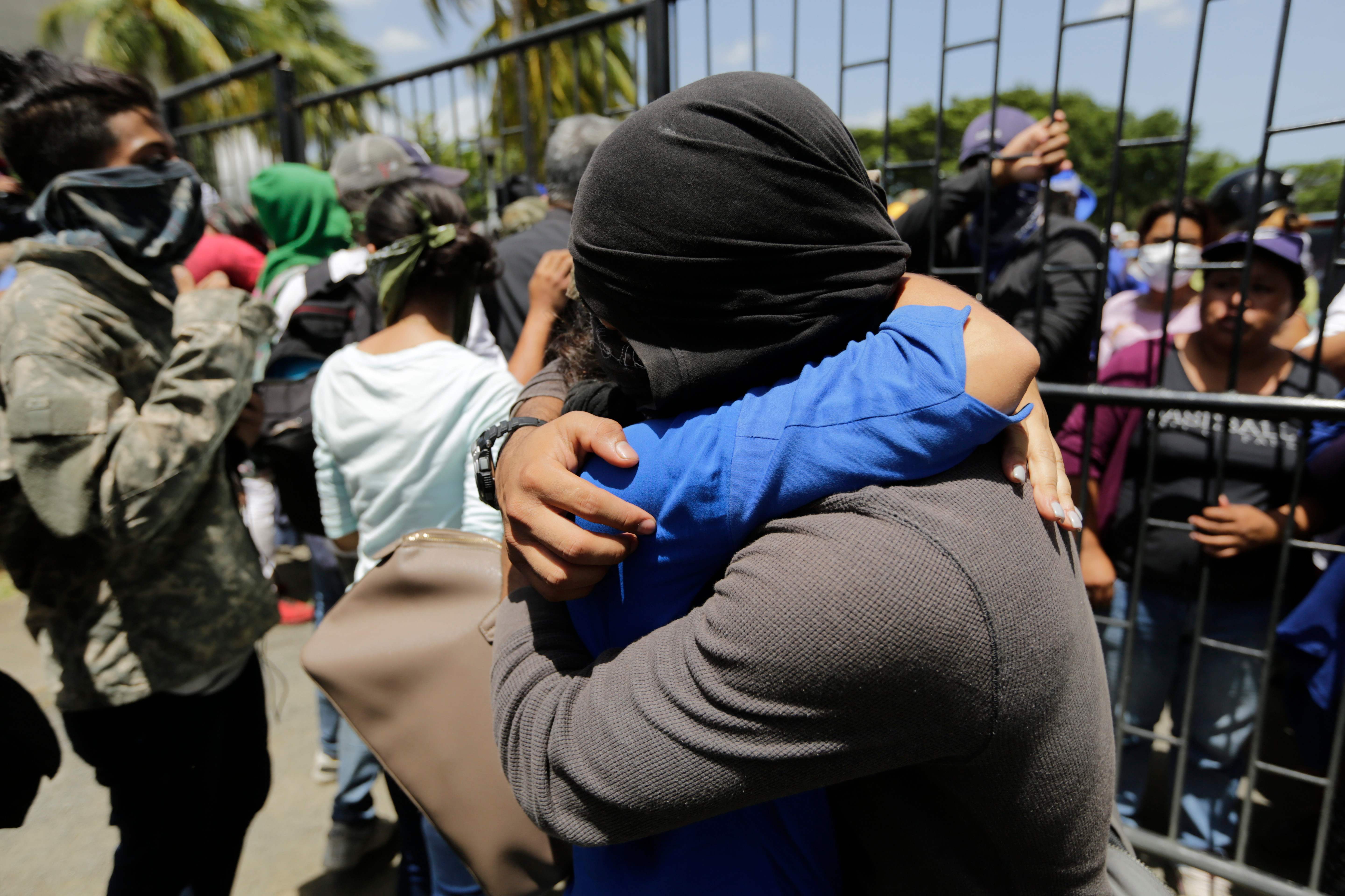 Un estudiante de la Universidad Nacional Autónoma de Nicaragua (UNAN), que se refugió durante la noche en una iglesia junto a sus compañeros durante un ataque de las fuerzas gubernamentales, abraza a sus familiares, a su llegada a la Catedral de Managua. Foto: AFP