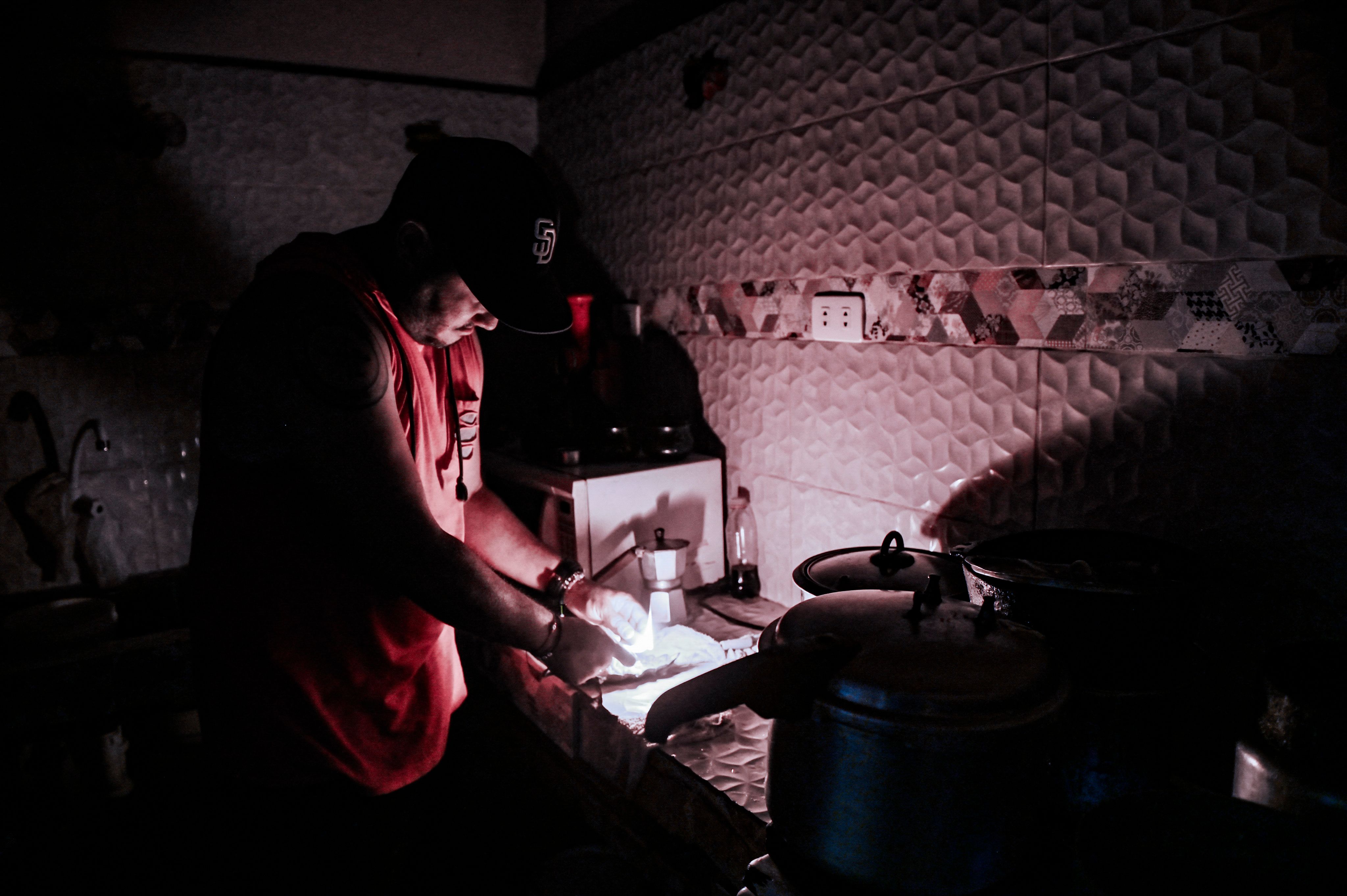(FILES) In this file photo taken on May 25, 2022, a man lights a candle during a blackout in Havana. - The daily blackouts in Cuba due to electricity shortages that have been occurring since May have caused irritation and unusual protests, which according to the government respond to the "counterrevolution," while the opposition considers these power outages to be "their best ally." (Photo by Yamil LAGE / AFP)