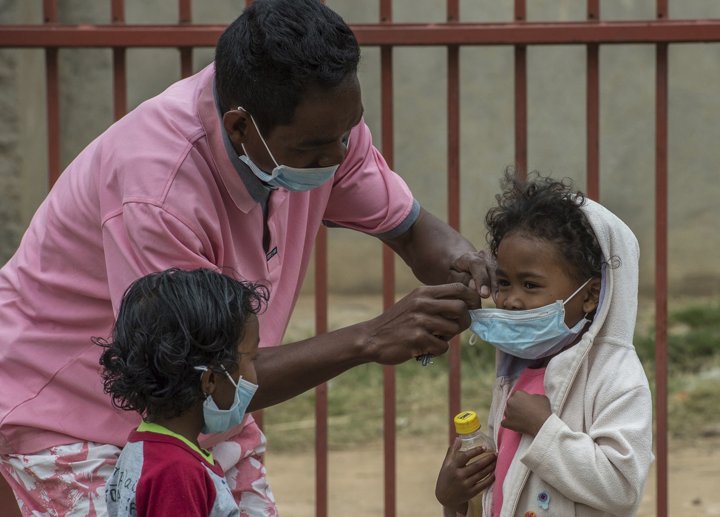 Un padre colocaba mascarillas a sus hijos en Antananarivo en un un intento por evitar el contagio de la peste.