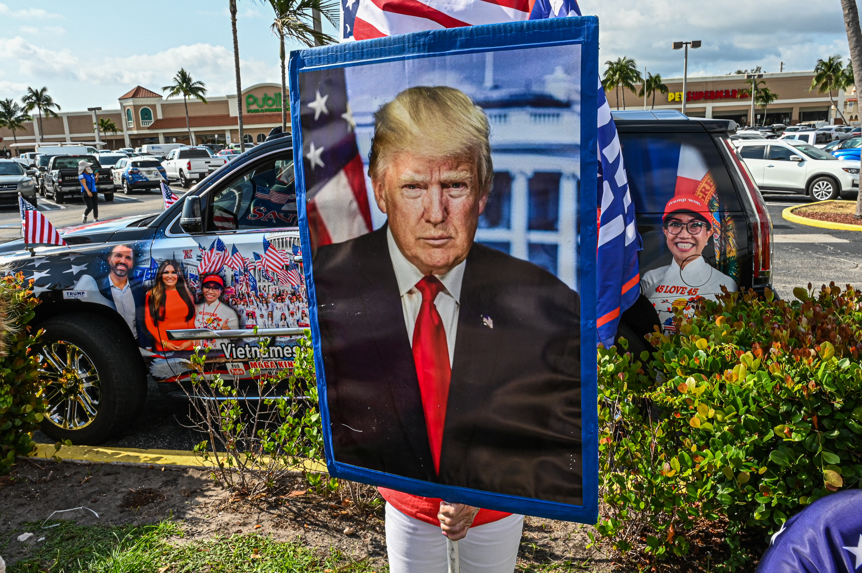Supporters of former US president Donald Trump react as his motorcade makes its way to Palm Beach International Airport in Palm Beach, Florida, on April 3, 2023. - Former US President Donald Trump is to be booked, fingerprinted, and will have a mugshot taken at a Manhattan courthouse on the afternoon of April 4, 2023, before appearing before a judge as the first ever American president to face criminal charges. (Photo by Giorgio Viera / AFP)
