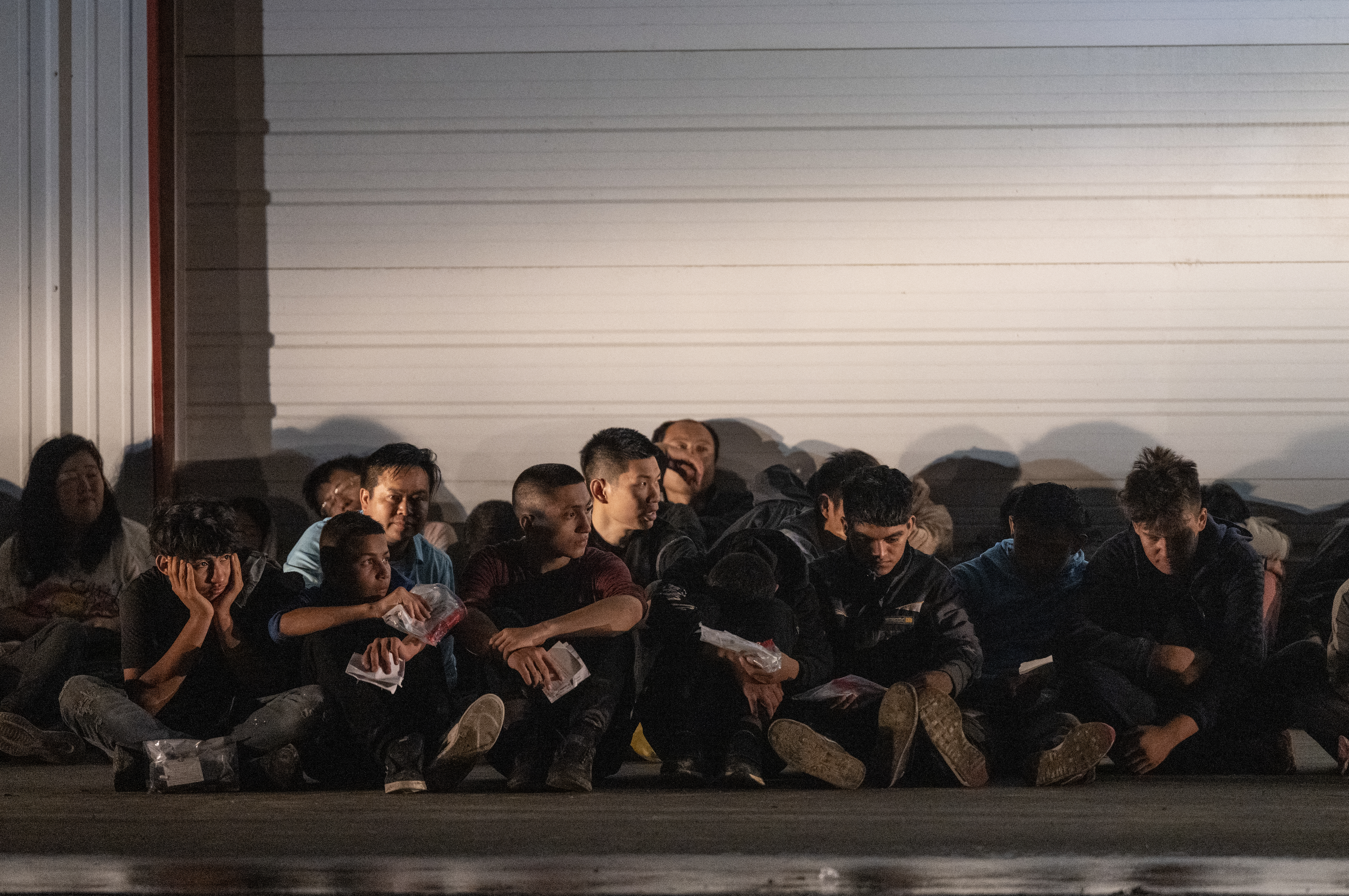Migrants wait for a bus to take them to a processing center after they turned themselves over to US Border Patrol agents after crossing over from Mexico in Fronton, Texas on May 12, 2023. The US-Mexico border appeared calm on May 12 as tough asylum rules come into force, with senior officials in Washington expressing confidence that the new system would work. (Photo by ANDREW CABALLERO-REYNOLDS / AFP)