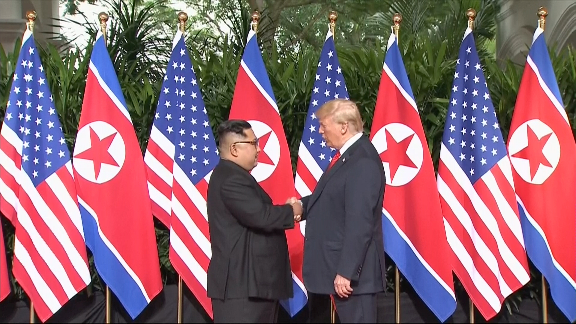 In this image made from video provided by Host Broadcaster Mediacorp Pte Ltd, U.S. President Donald Trump and North Korean leader Kim Jong Un shake hands ahead of their meeting at Capella Hotel in Singapore, Tuesday, June 12, 2018. (Host Broadcaster Mediacorp Pte Ltd via AP)