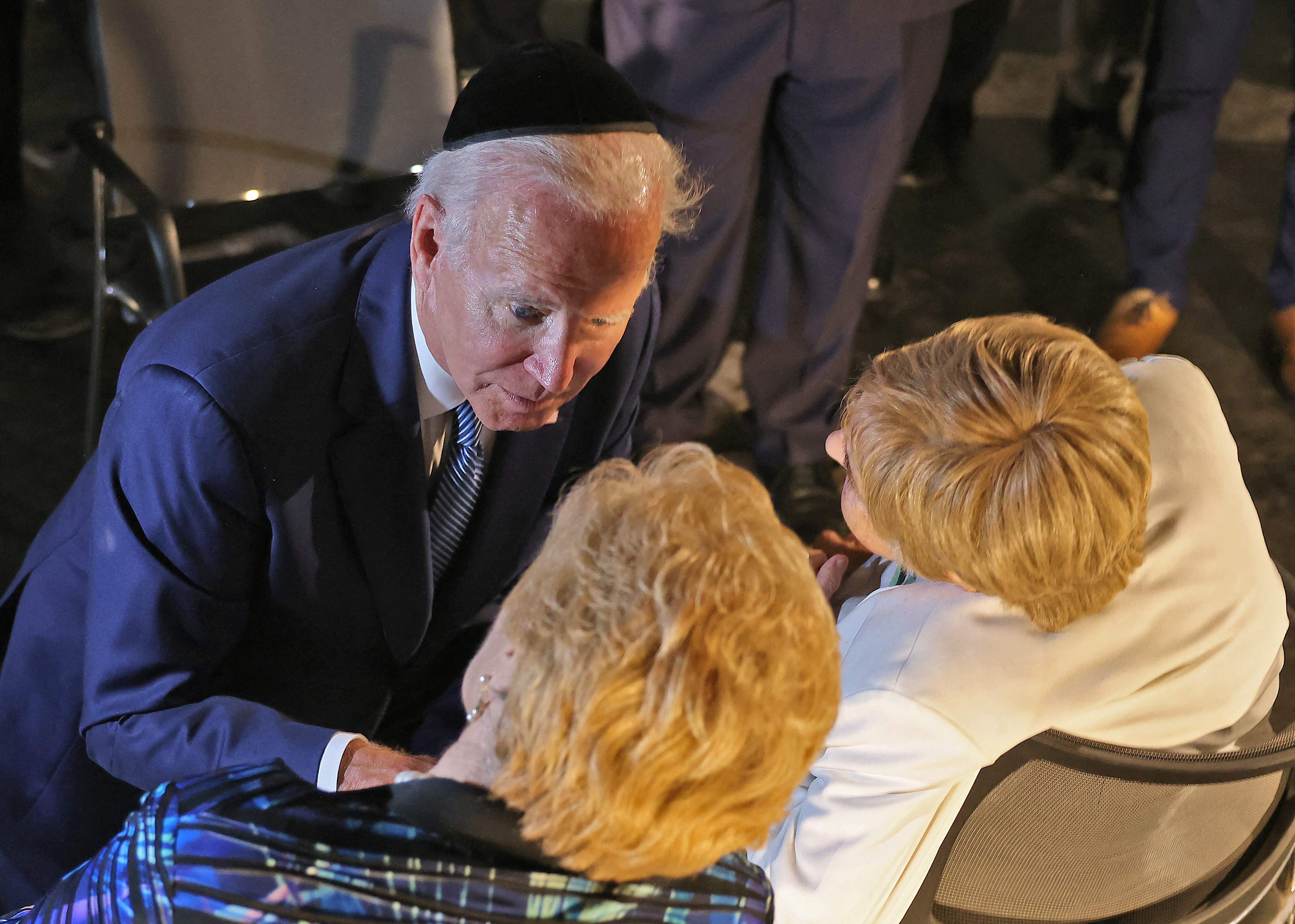 US President Joe Biden speaks with Holocaust survivors Giselle Cycowicz (bottom-R) and Rena Quint (bottom-L), at the Hall of Remembrance of the Yad Vashem Holocaust Memorial museum in Jerusalem, on July 13, 2022. (Photo by Menahem KAHANA / various sources / AFP)