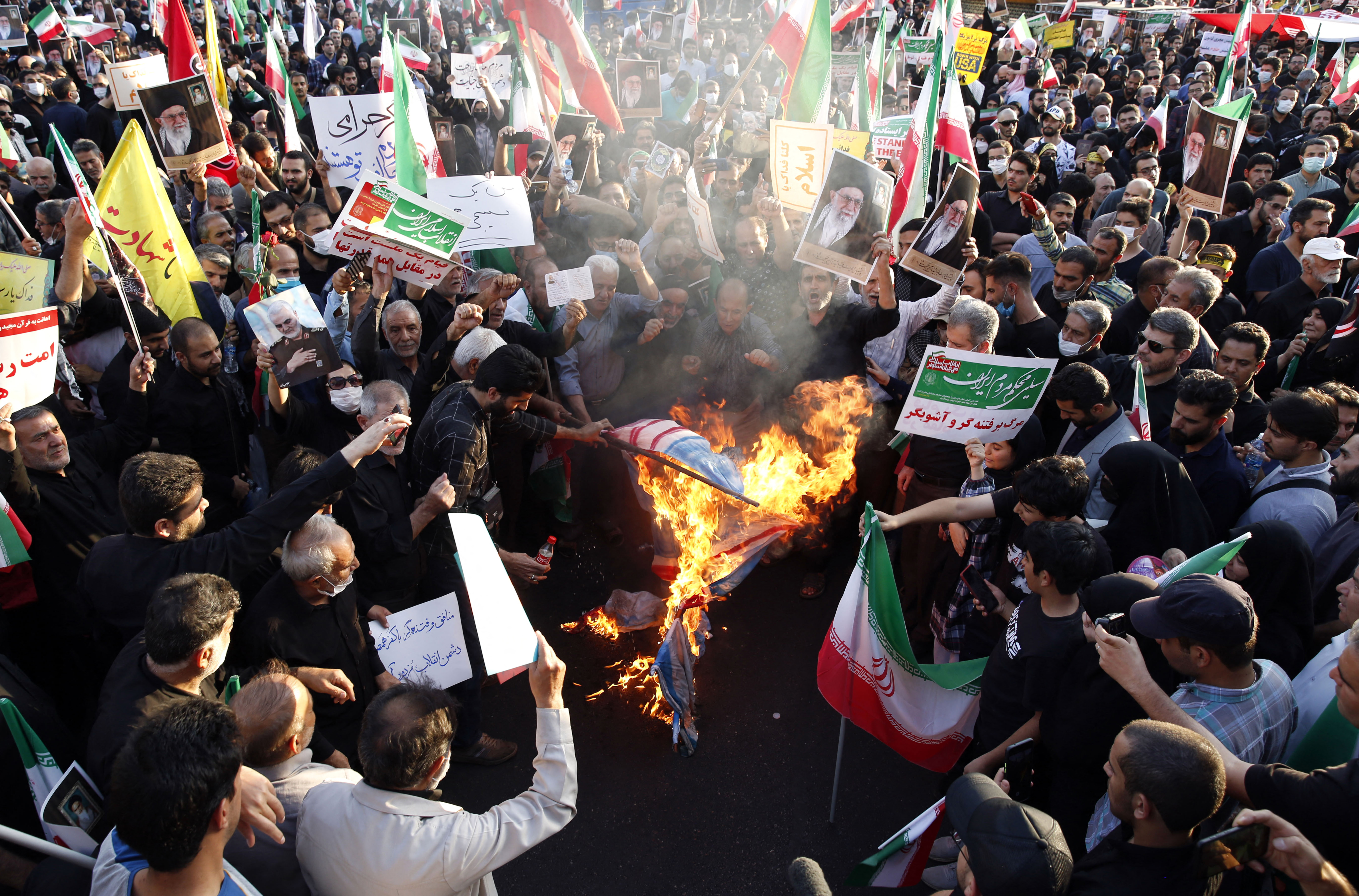 Iranian pro-government protesters burn flags of the US, Israel and Britain during a rally against the recent anti-government protests in Iran, in Tehran, on September 25, 2022. - Iran's judiciary chief vowed no leniency against the wave of unrest that has rocked the country since the death of young Kurdish woman Mahsa Amini in the custody of the morality police. (Photo by AFP)