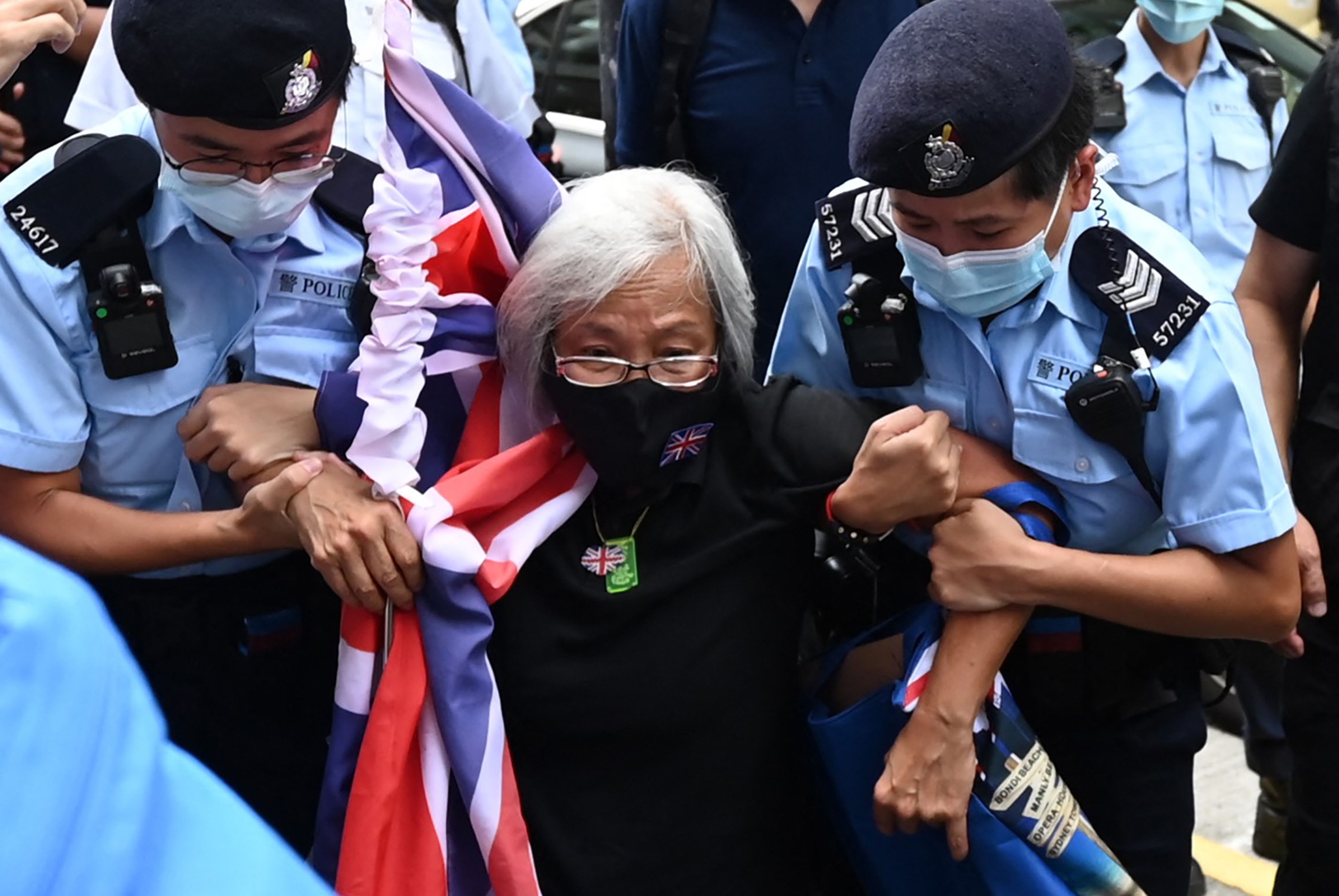 (FILES) In this file photo taken on July 01, 2021, activist Alexandra Wong (C), also known as Grandma Wong, is taken away by police while protesting on the 24th anniversary of Hong Kong's handover from Britain, in Hong Kong. - US President Joe Biden announced on August 5, 2021, that Hong Kong citizens currently in the US, who fear for their safety amid the political crackdown back home, will receive temporary safe haven. Biden said the move recognizes "the significant erosion" of rights and freedoms in Hong Kong by the Chinese government. (Photo by Peter PARKS / AFP)