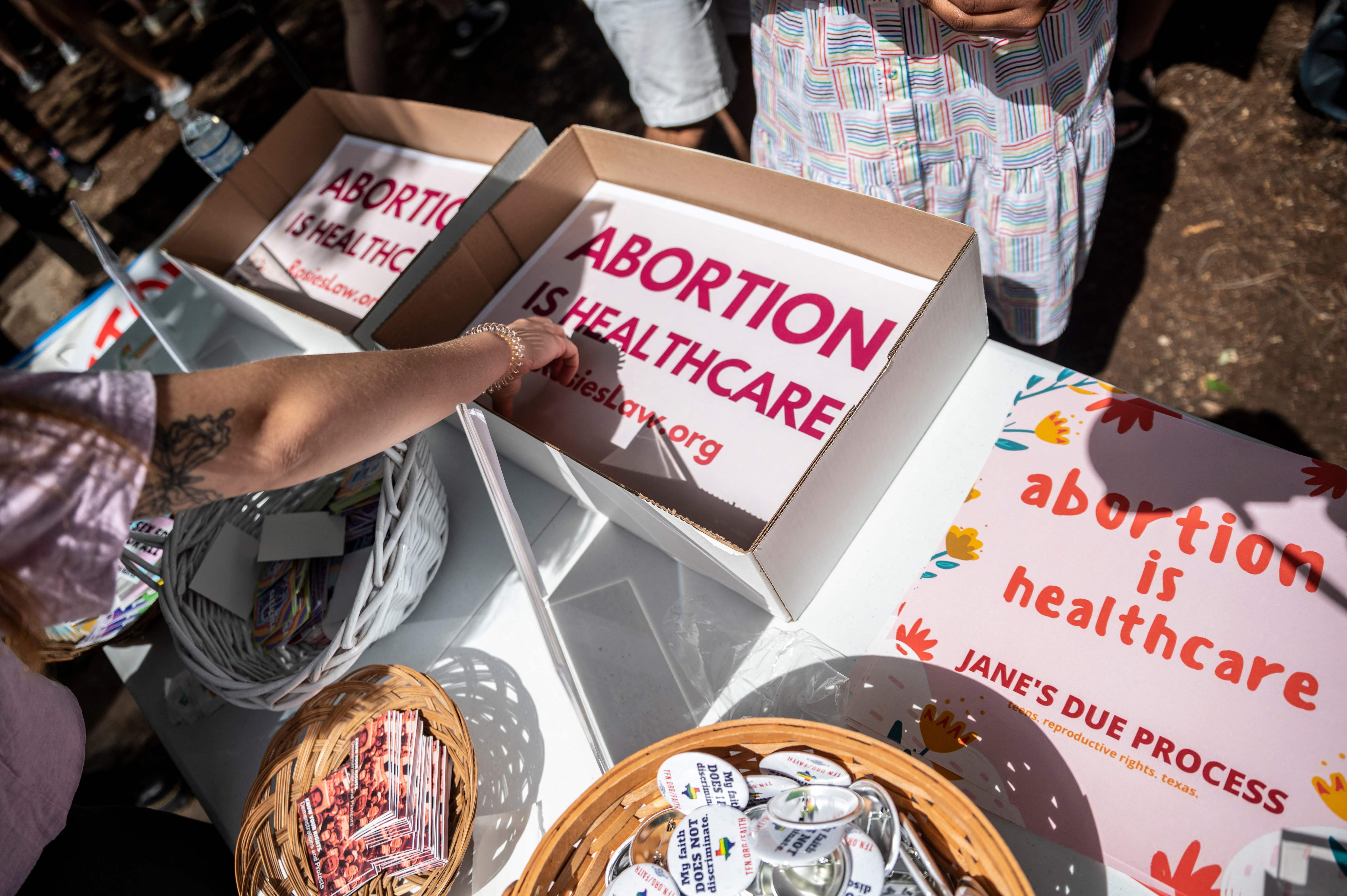(FILES) In this file photo attendees grab signs at a protest outside the Texas state capitol on May 29, 2021 in Austin, Texas. - A Texas law that bans abortion after six weeks, and makes no exception for rape or incest, took effect on September 1, 2021 after the Supreme Court did not act on an emergency request to block it. Governor Greg Abbott, a Republican, signed the bill in May, making Texas one of a dozen states banning abortion once a fetal heartbeat can be detected -- which is usually in the sixth week of pregnancy. (Photo by SERGIO FLORES / GETTY IMAGES NORTH AMERICA / AFP)