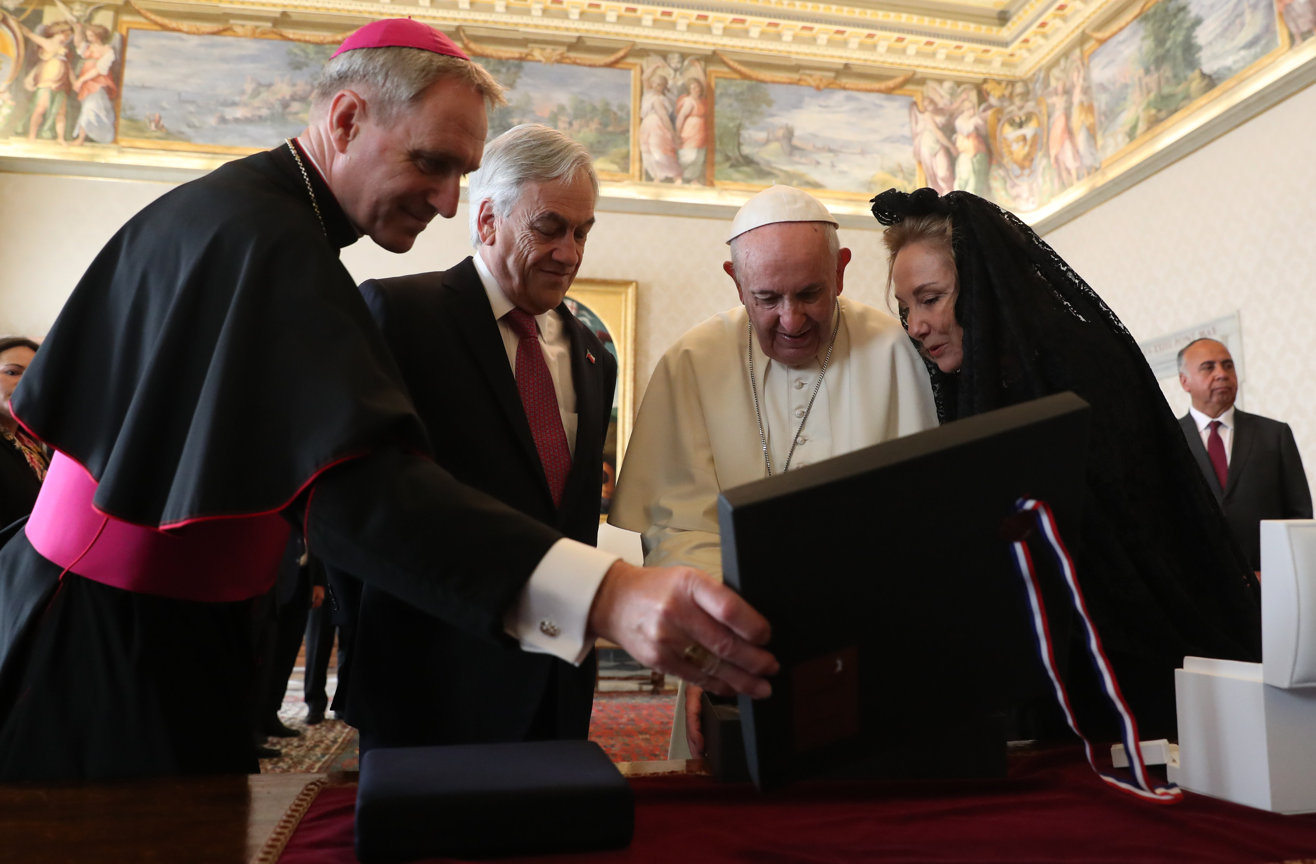 Chile's President Sebastian Pinera (2L) and his wife Cecilia Morel (R) exchange gifts with Pope Francis (2R) during a private audience at the Vatican on October 13, 2018. (Photo by Alessandro BIANCHI / POOL / AFP)