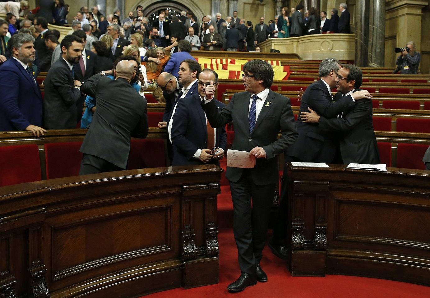 El presidente del Gobierno catalán, Carles Puigdemont, gesticulaba mientras los legisladores se congratulaban tras la votación que, este viernes 27 de octubre, declaró la independencia de la región.