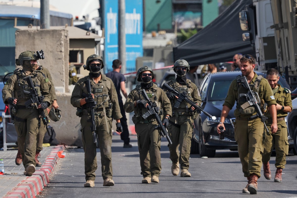 Soldados israelíes se reúnen en el lugar de un intercambio de disparos ocurrido horas antes entre palestinos armados y fuerzas israelíes, tras un incidente en el puesto de control norte de Hebrón, en la Cisjordania ocupada por Israel.