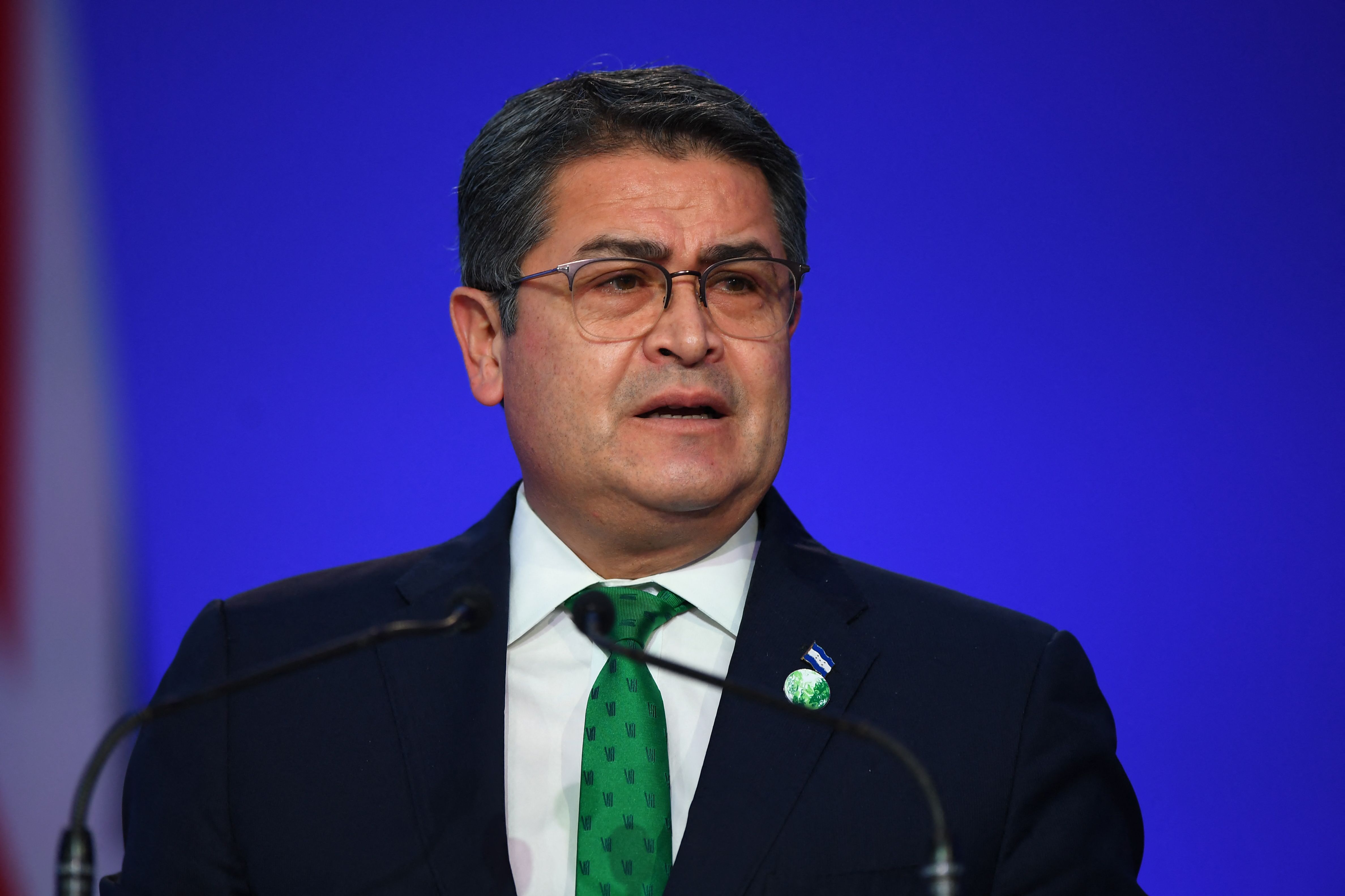 (FILES) In this file photo taken on November 1, 2021, Honduras' President Juan Orlando Hernandez presents his national statement as part of the World Leaders' Summit of the COP26 UN Climate Change Conference in Glasgow, Scotland. - US requested Honduras to extradite former president Juan Orlando Hernandez (2014-2022), who is accused of drug trafficking, official sources close to the process informed AFP on February 14, 2022. (Photo by ANDY BUCHANAN / POOL / AFP)