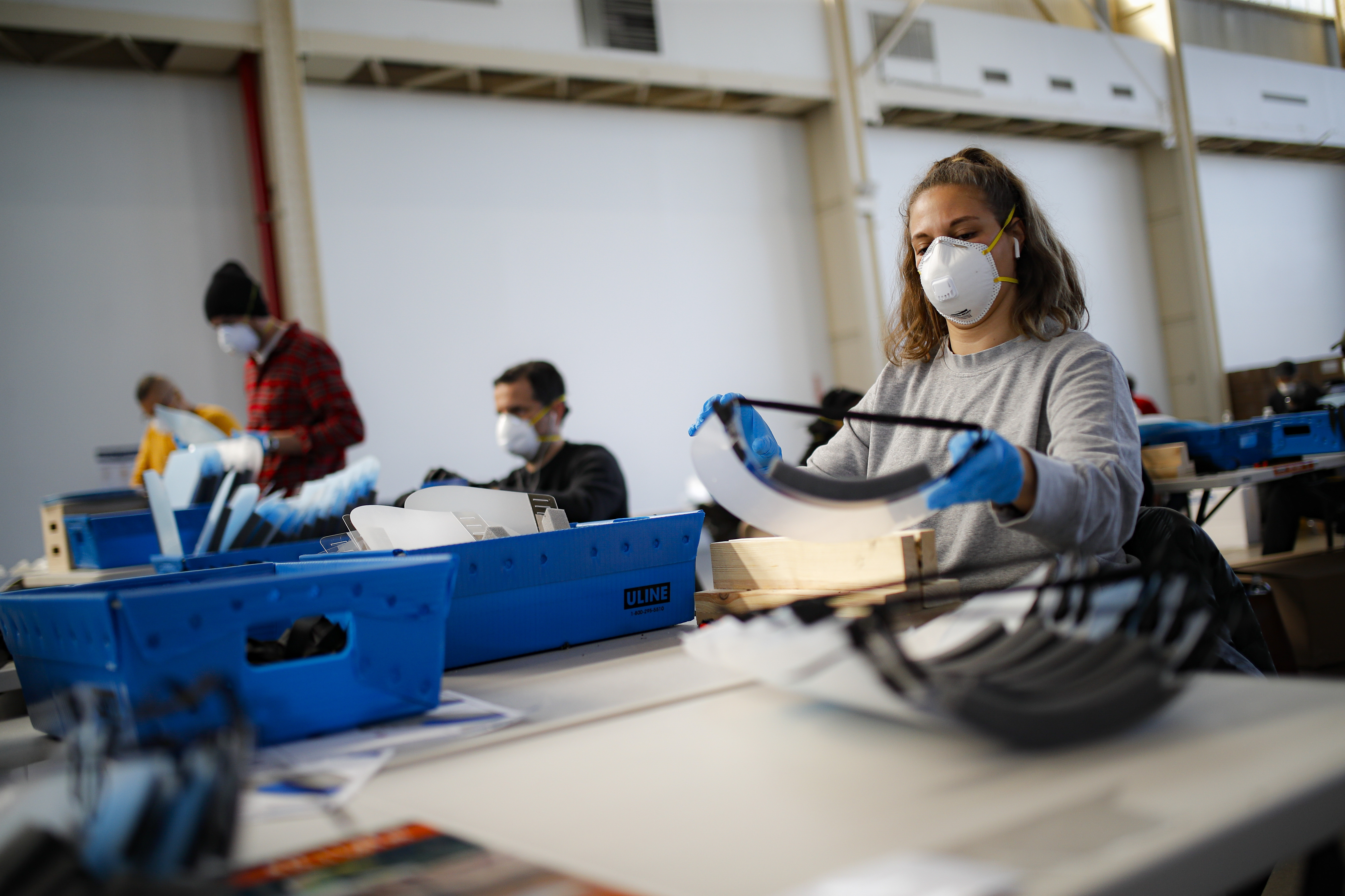 A worker wearing personal protective equipment builds a splash guard during a mass manufacturing operation to supply New York City government with protection to distribute against COVID-19 transmission, Friday, March 27, 2020, at the Brooklyn Navy Yard in New York. The new coronavirus causes mild or moderate symptoms for most people, but for some, especially older adults and people with existing health problems, it can cause more severe illness or death. (AP Photo/John Minchillo)