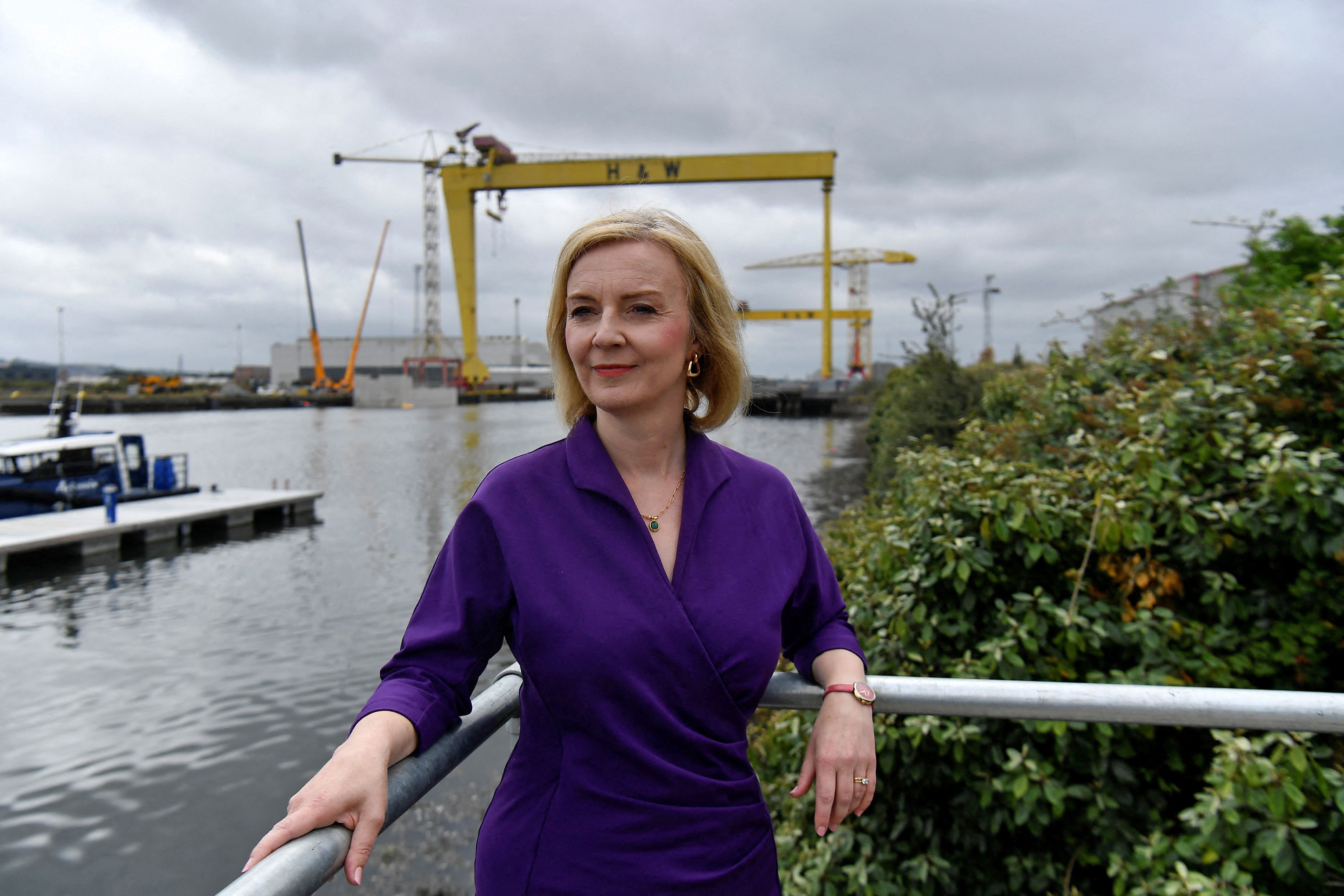 (FILES) In this file photo taken on August 17, 2022 Contender to become the country's next Prime minister and leader of the Conservative party British Foreign Secretary Liz Truss (C) poses for a photograph with the Harland and Wolff shipyard cranes at a Conservative Party leadership campaign event, at Artemis Technologies in Belfast Harbour, Belfast. - Liz Truss has emerged as the clear favourite to succeed Boris Johnson as leader of the ruling Conservative party and UK prime minister, using her political experience to pull ahead of challenger Rishi Sunak. (Photo by CLODAGH KILCOYNE / POOL / AFP)