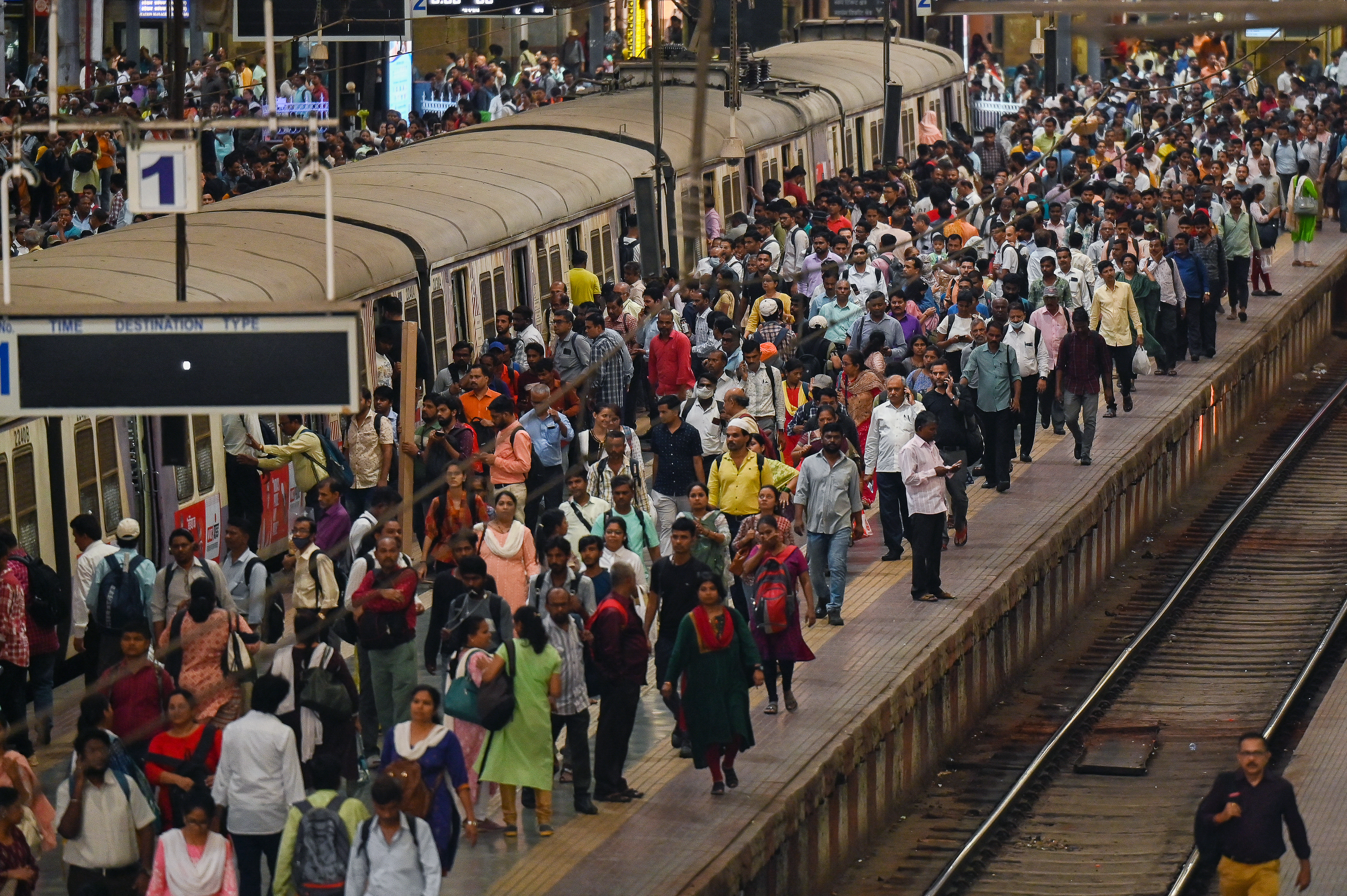 People crowd on platforms as they wait for their train at the Chhatrapati Shivaji Terminus (CST) railway station Mumbai on April 19, 2023. - India is set to overtake China as the world's most populous country by the end of June, UN estimates showed on April 19, 2023, posing huge challenges to a nation with creaking infrastructure and insufficient jobs for millions of young people. (Photo by Punit PARANJPE / AFP)