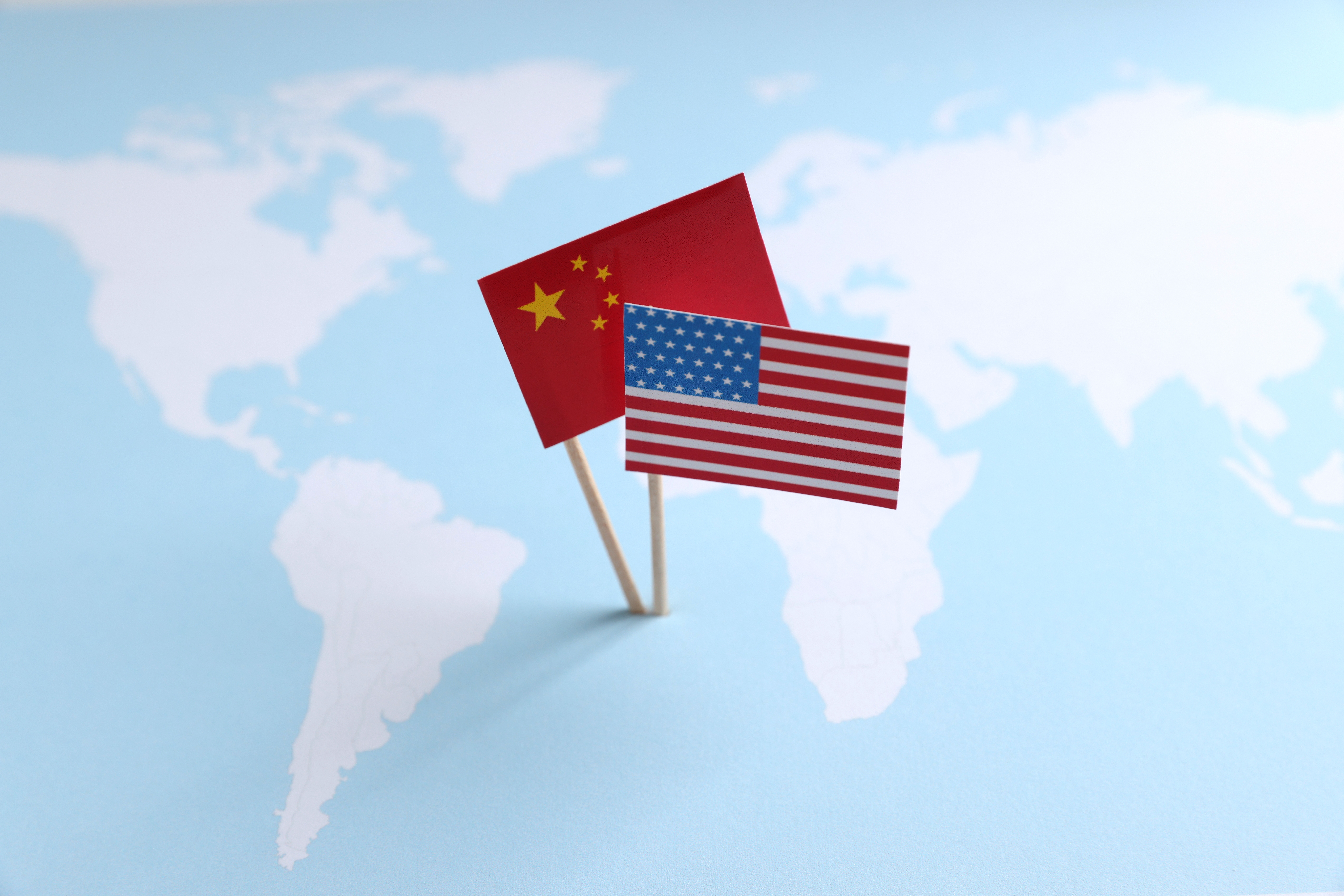 Mapa de América con superposición de banderas de China y Estados Unidos.