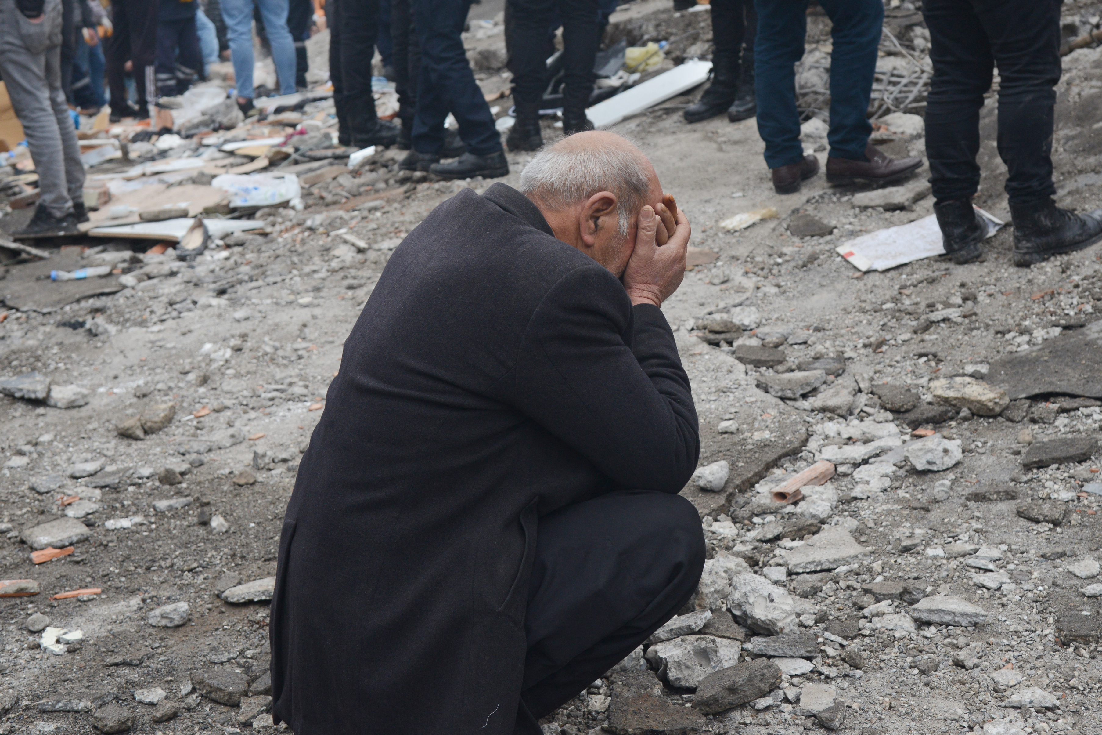 A man reacts as people search for survivors through the rubble in Diyarbakir, on February 6, 2023, after a 7.8-magnitude earthquake struck the country's south-east. - At least 284 people died in Turkey and more than 2,300 people were injured in one of Turkey's biggest quakes in at least a century, as search and rescue work continue in several major cities. (Photo by ILYAS AKENGIN / AFP)
