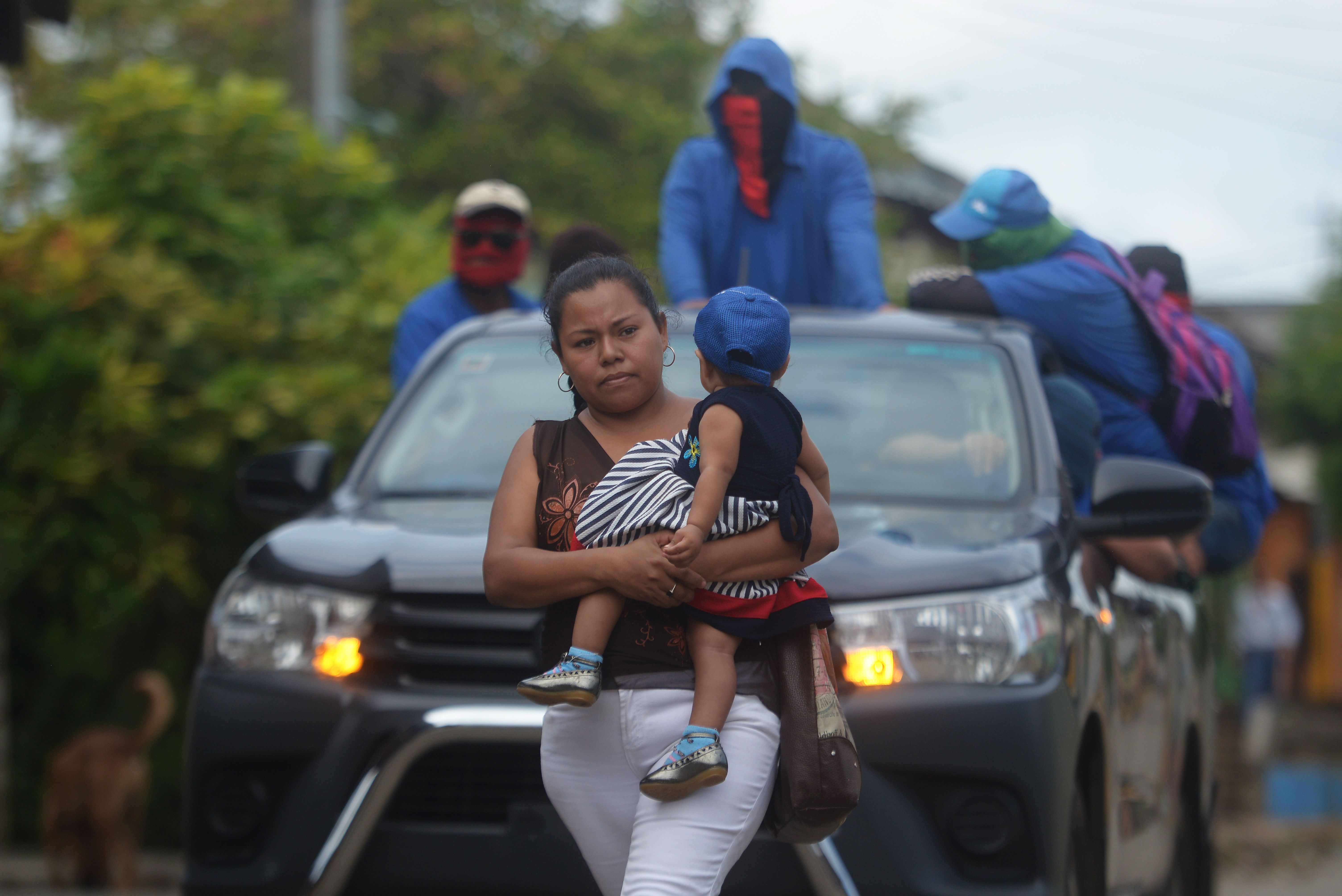 A woman holding a baby as paramilitaries drive on a truck at Monimbo neighborhood in Masaya, Nicaragua, on July 18, 2018, following clashes with anti-government demonstrators.
The head of the Inter-American Commission on Human Rights has described as "alarming" the ongoing violence in Nicaragua, where months of clashes between protesters and the forces of President Daniel Ortega have claimed almost 300 lives. / AFP PHOTO / MARVIN RECINOS