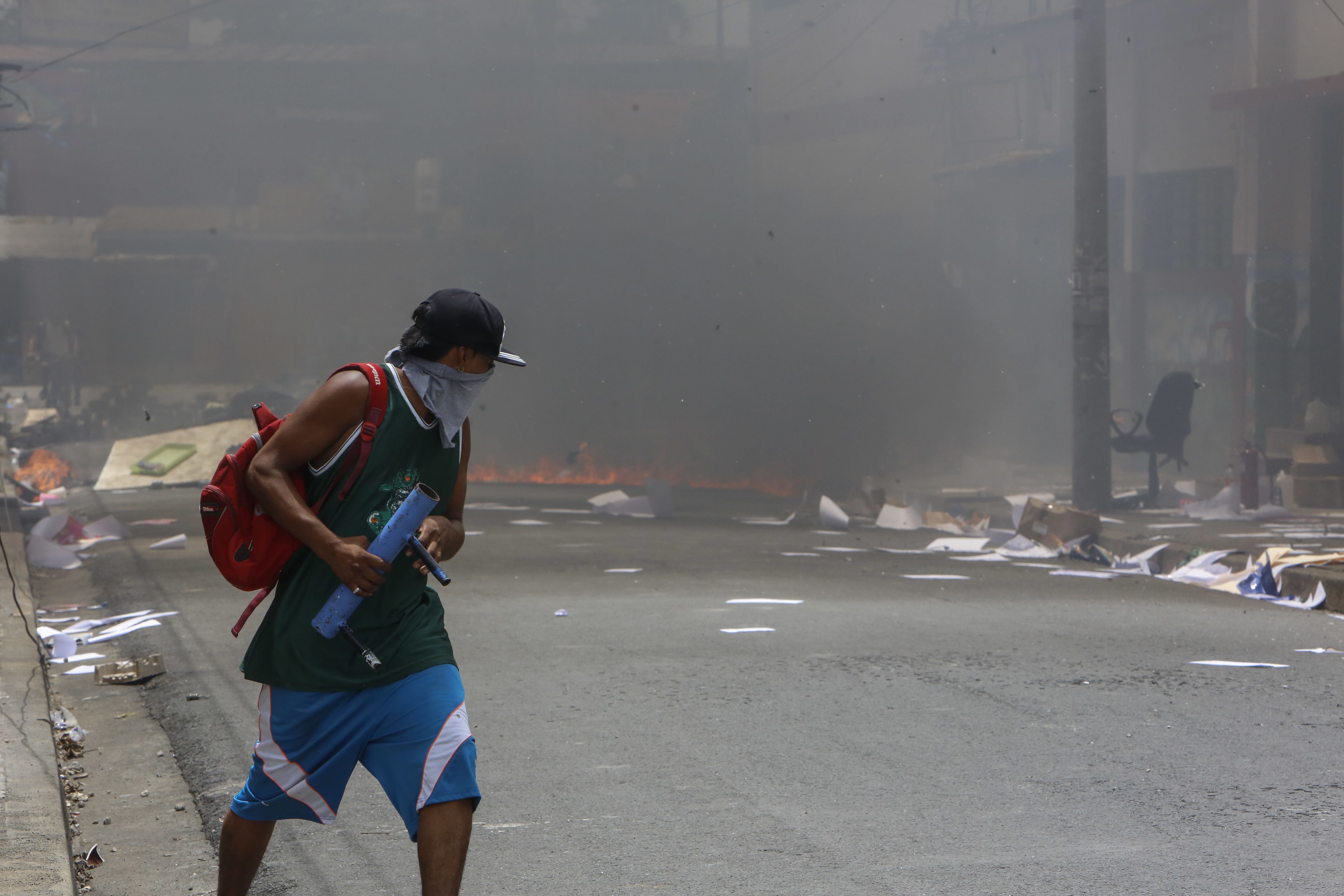 A masked protester runs near a burning barricade in the Monimbo neighborhood during clashes with police, in Masaya, Nicaragua, Saturday, June 2, 2018. More than 110 people have been killed in Nicaragua during clashes between forces loyal to President Daniel Ortega and opposition groups. (AP Photo/Alfredo Zuniga)