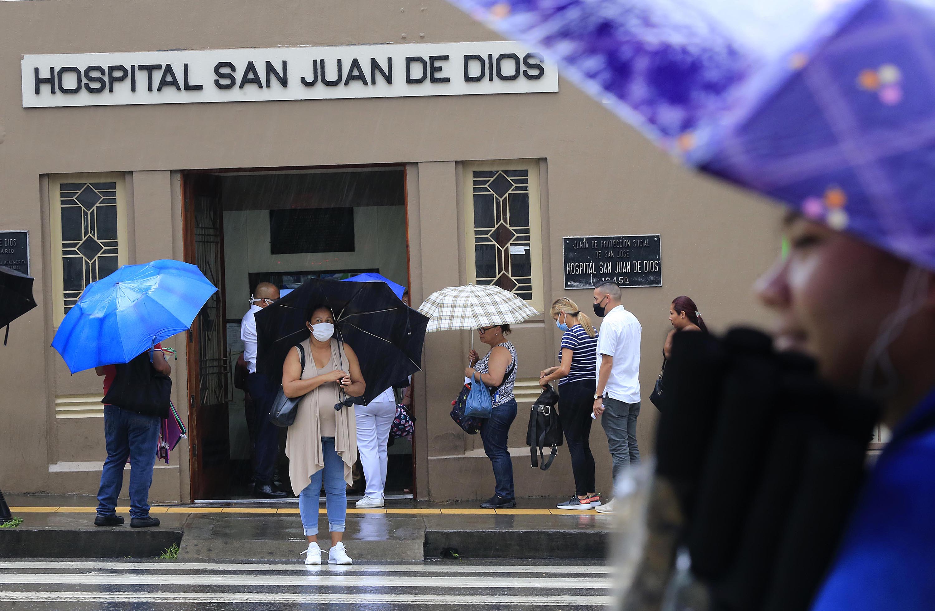 17/06/2020 Hospital San Juan de Dios. Gente ingresando y saliendo, usando mascarillas y/o caretas y, además con sombrillas o paraguas para protegerse de la lluvia. Foto: Rafael Pacheco