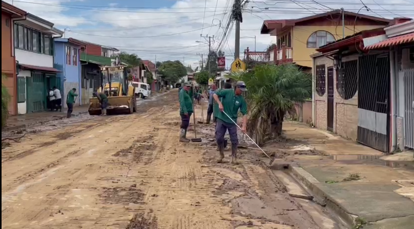 Cuadrillas del AyA, del municipio y vecinos de Gravilias, aprovecharon que en la mañana no llovió para rehabilitar las calles, y impiar el barro de las casas. Foto: Alonso Tenorio.