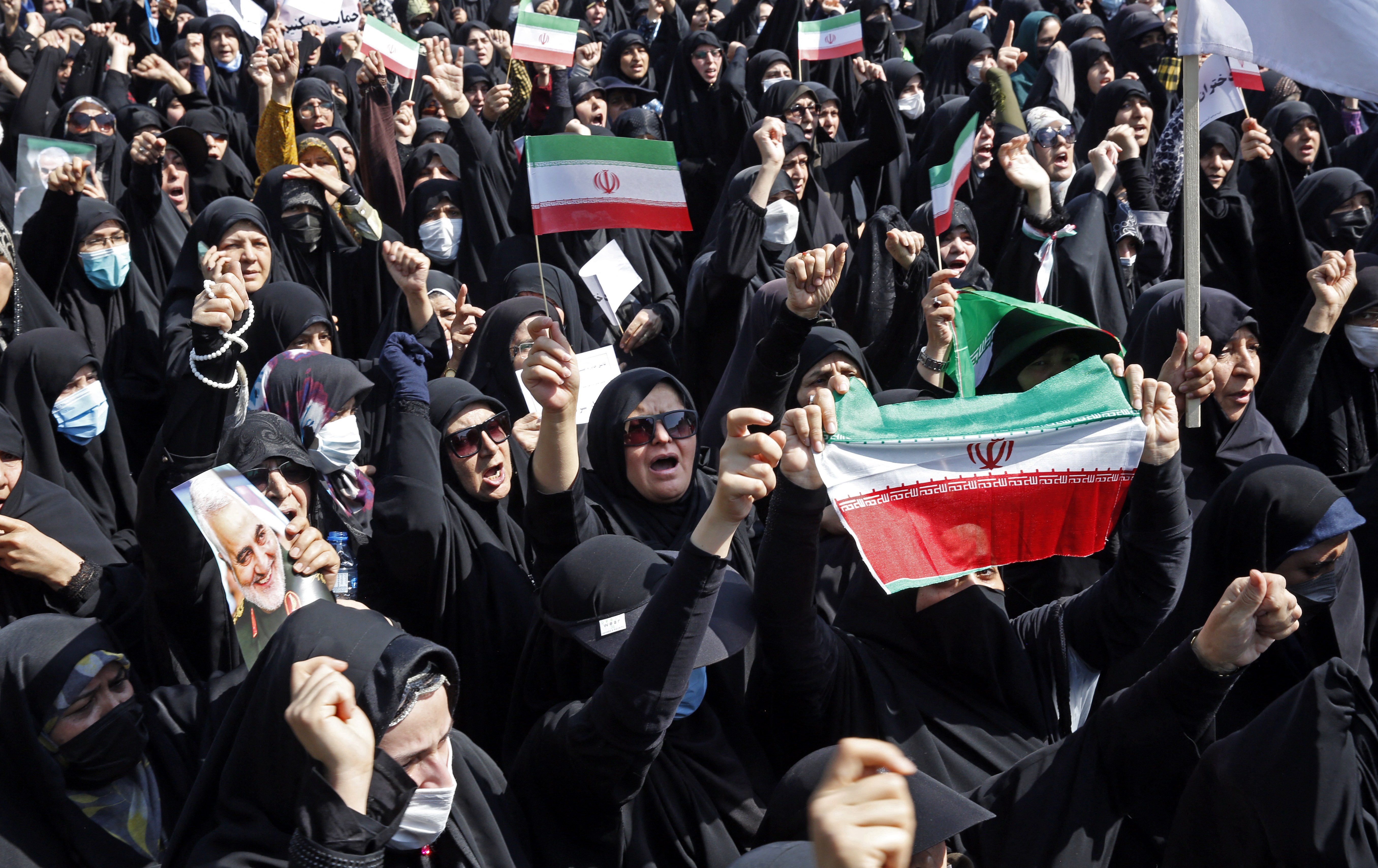 Iranians wave the national flag as they march during a pro-hijab rally in the capital Tehran on September 23, 2022. - Thousands of people marched through Iran's capital during a pro-hijab rally Friday, paying tribute to security forces who have moved to quell a week of protests by what media called "conspirators". Iran has been rocked by street violence that has claimed the lives of at least 17 people since the death last week of Mahsa Amini, who had been detained for wearing the hijab headscarf in an "improper" way. State news agency IRNA said thousands of people took to the streets of Tehran on Friday after the main weekly prayers, in response to a call from Iran's Islamic Development Coordination Council. (Photo by AFP)