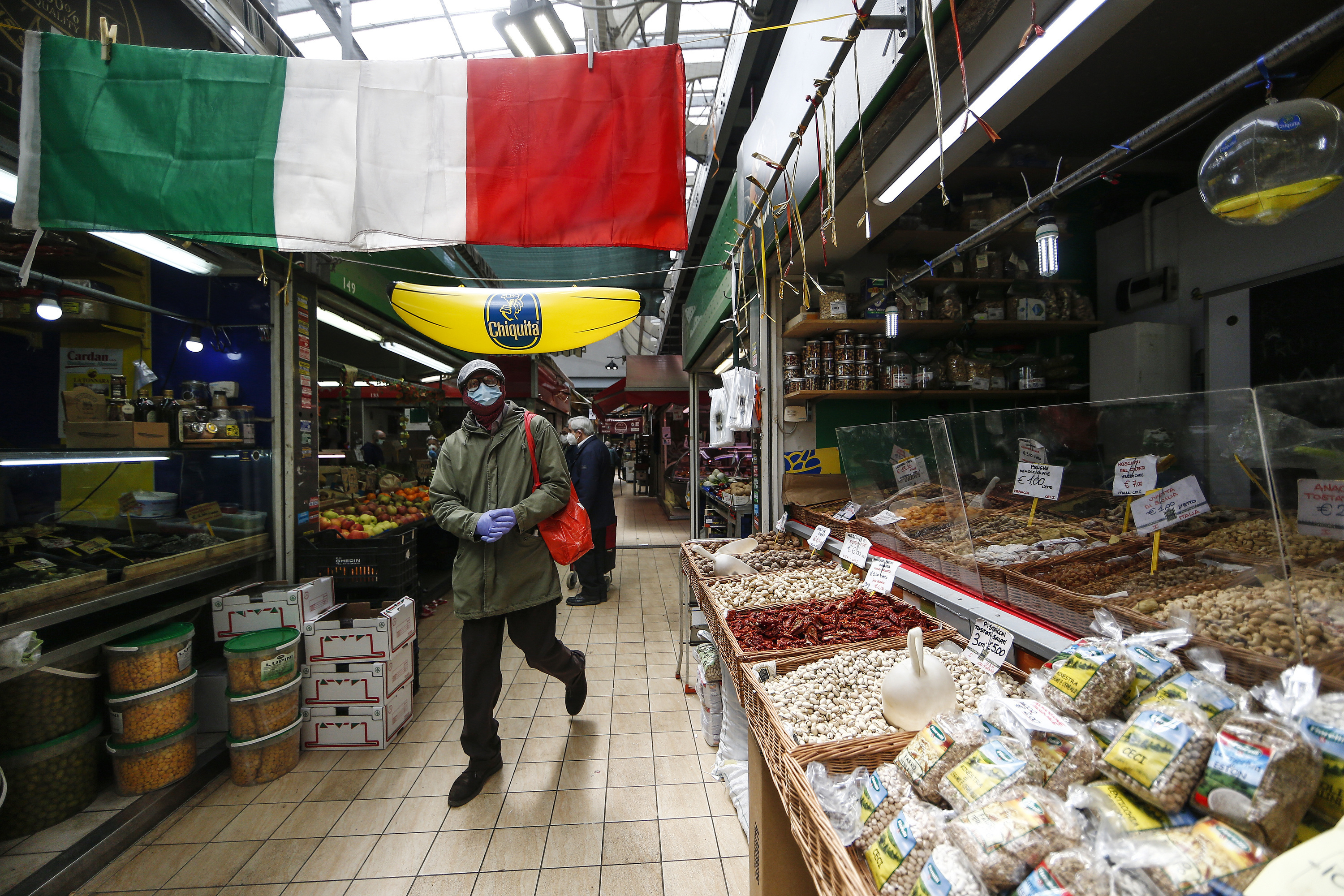 People shop in a covered market in downtown Rome Friday, April 17, 2020. Covered markets were among the activities that were allowed to continue working open during the coronavirus outbreak in Italy. (Cecilia Fabiano/LaPresse via AP)