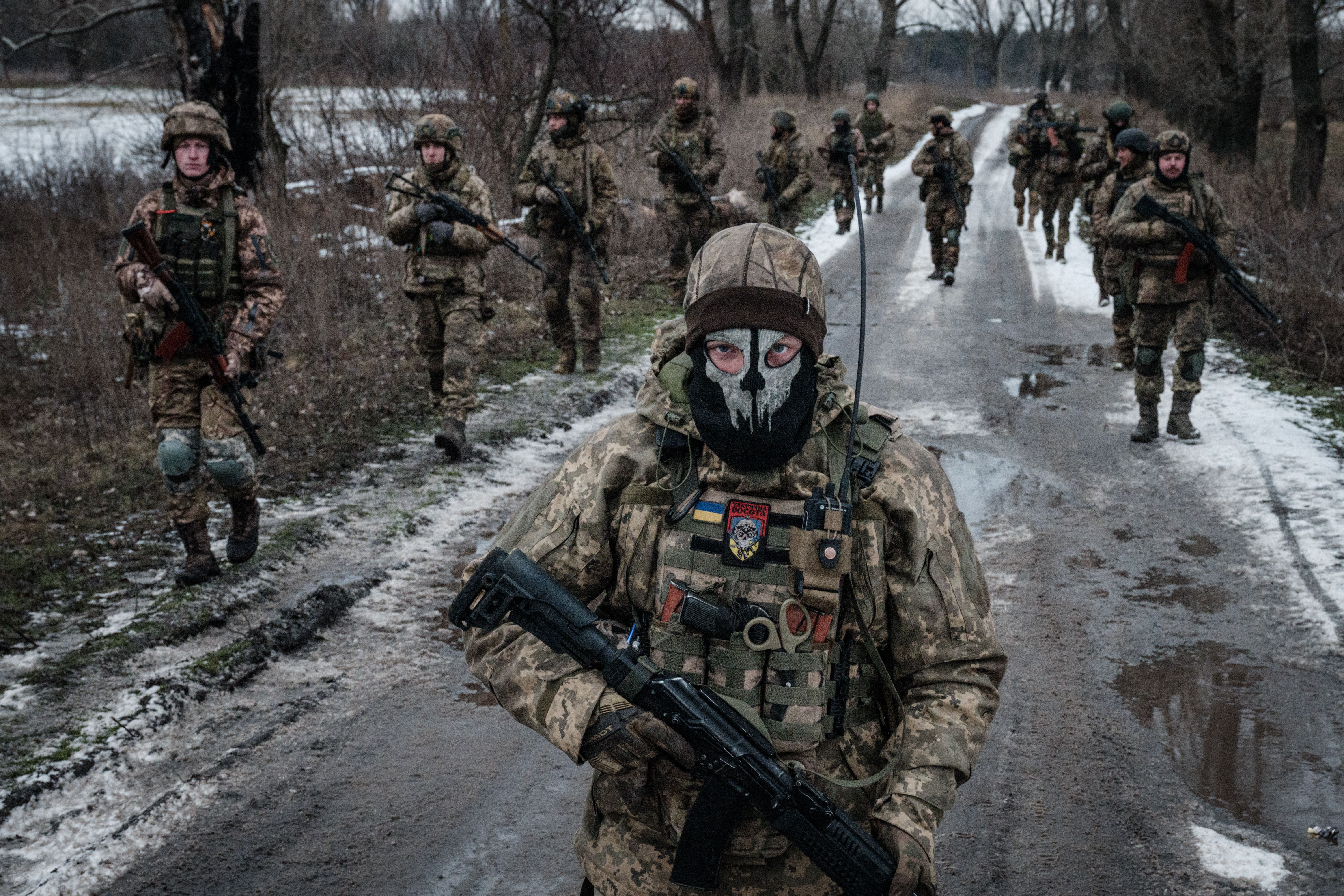 (FILES) Ukrainian servicemen walk on the road toward their base near the frontline in the Donetsk region on February 4, 2023, amid the Russian invasion of Ukraine. (Photo by YASUYOSHI CHIBA / AFP)