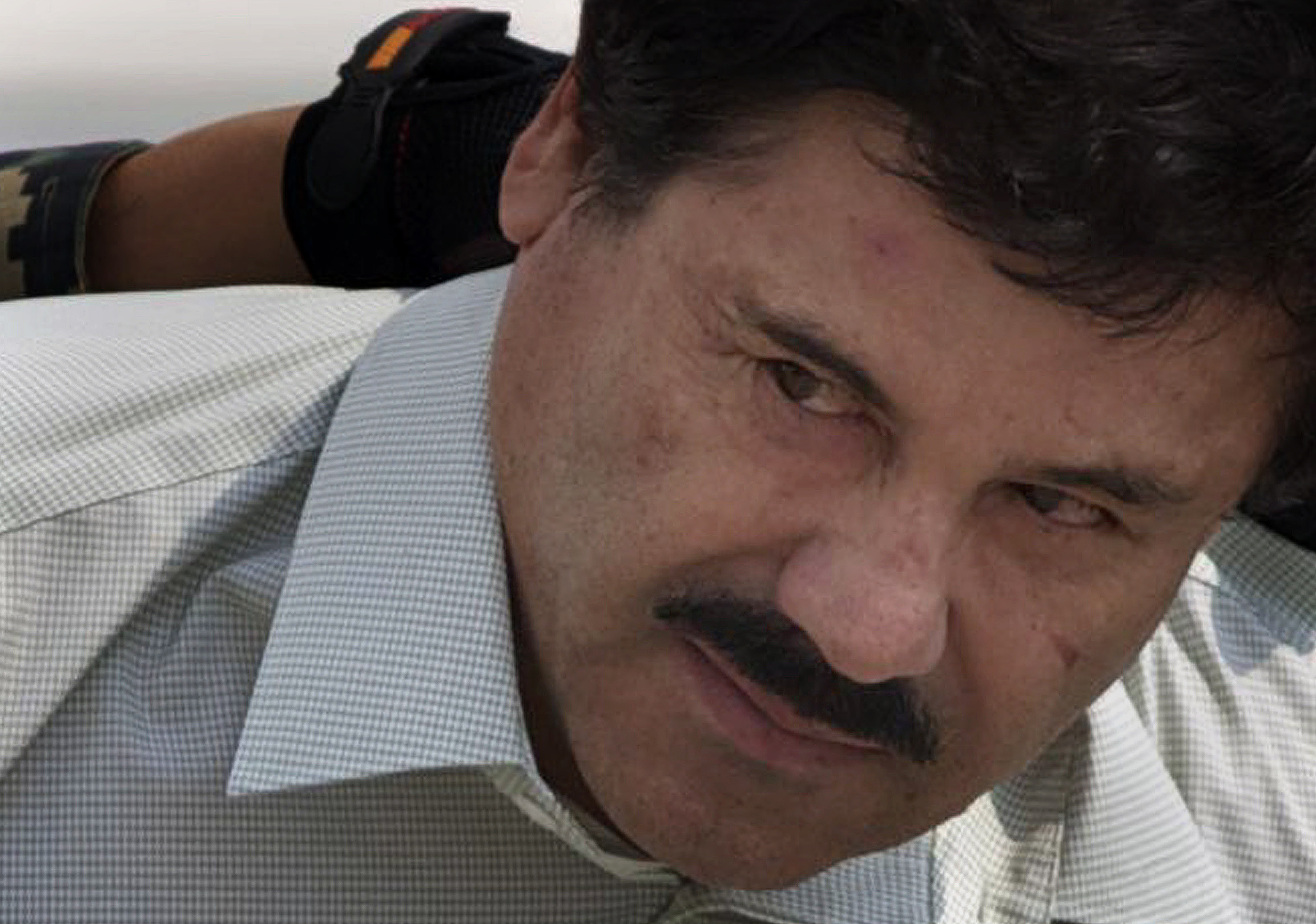 Joaquín EL Chapo Guzmán fue escoltado por policías mexicanos el 22 de febrero del 2014. El capo se encuentra oculto en las montañas de Sinaloa, según una fuente oficial.