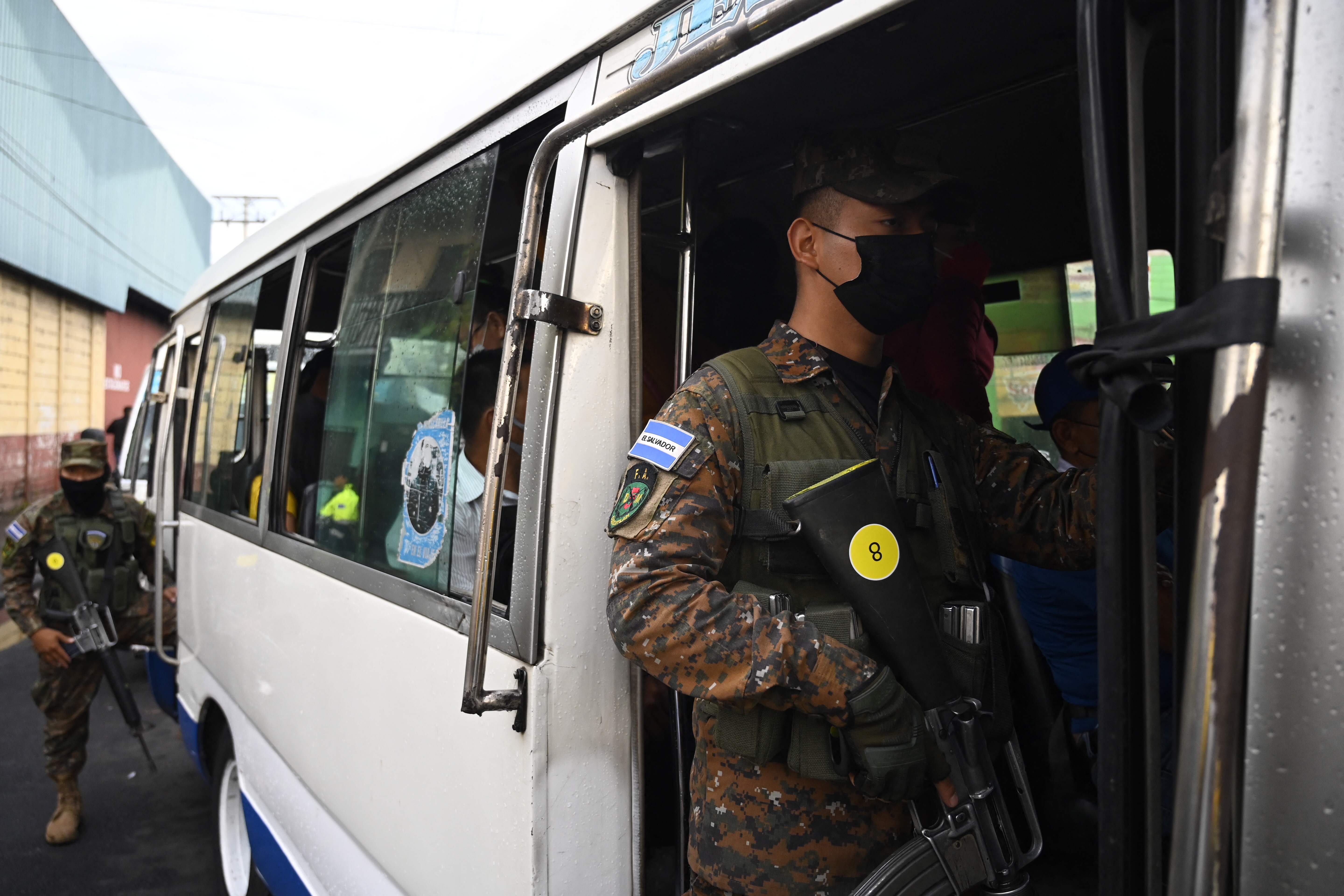 Soldiers are seen on a public transport bus in San Salvador on March 16, 2022. - The government intervened two routes of collective transport after the illegal increase in the cost of the ticket by now captured transport entrepreneur Catalino Miranda, who is also charged with the crimes of resistance and public disorder. (Photo by MARVIN RECINOS / AFP)