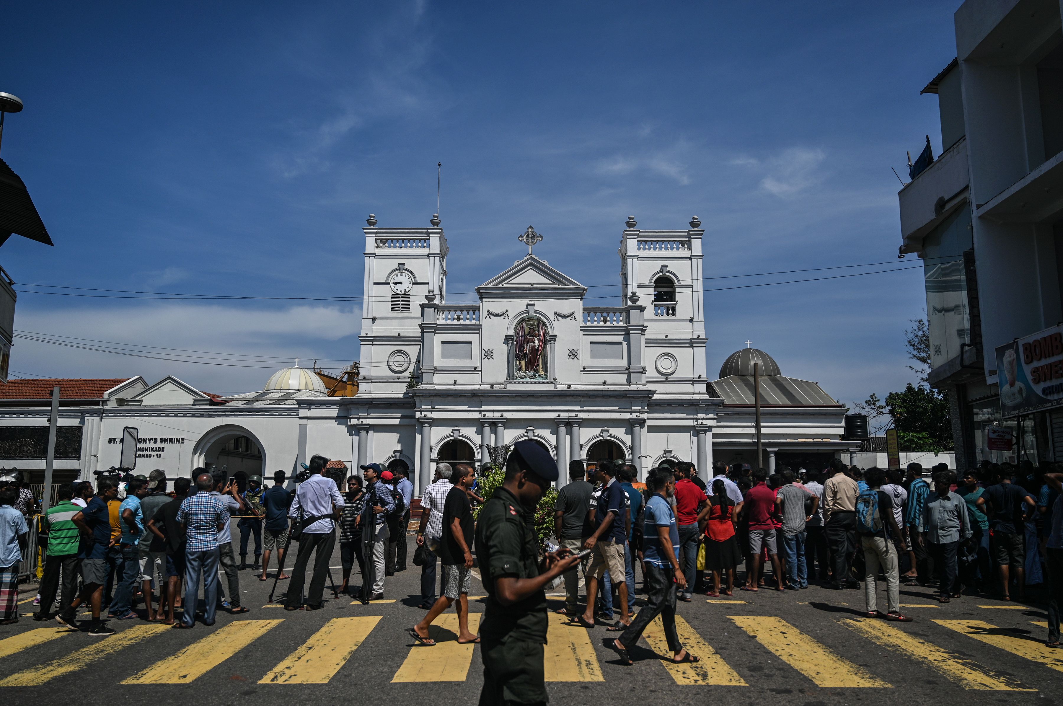 Local residents gather outside the St. Anthony's Shrine in Colombo on April 22, 2019, a day after the building was hit as part of a series of bomb blasts targeting churches and luxury hotels in Sri Lanka. - The death toll from bomb blasts that ripped through churches and luxury hotels in Sri Lanka rose dramatically April 22 to 290 -- including dozens of foreigners -- as police announced new arrests over the country's worst attacks for more than a decade. (Photo by Mohd RASFAN / AFP)