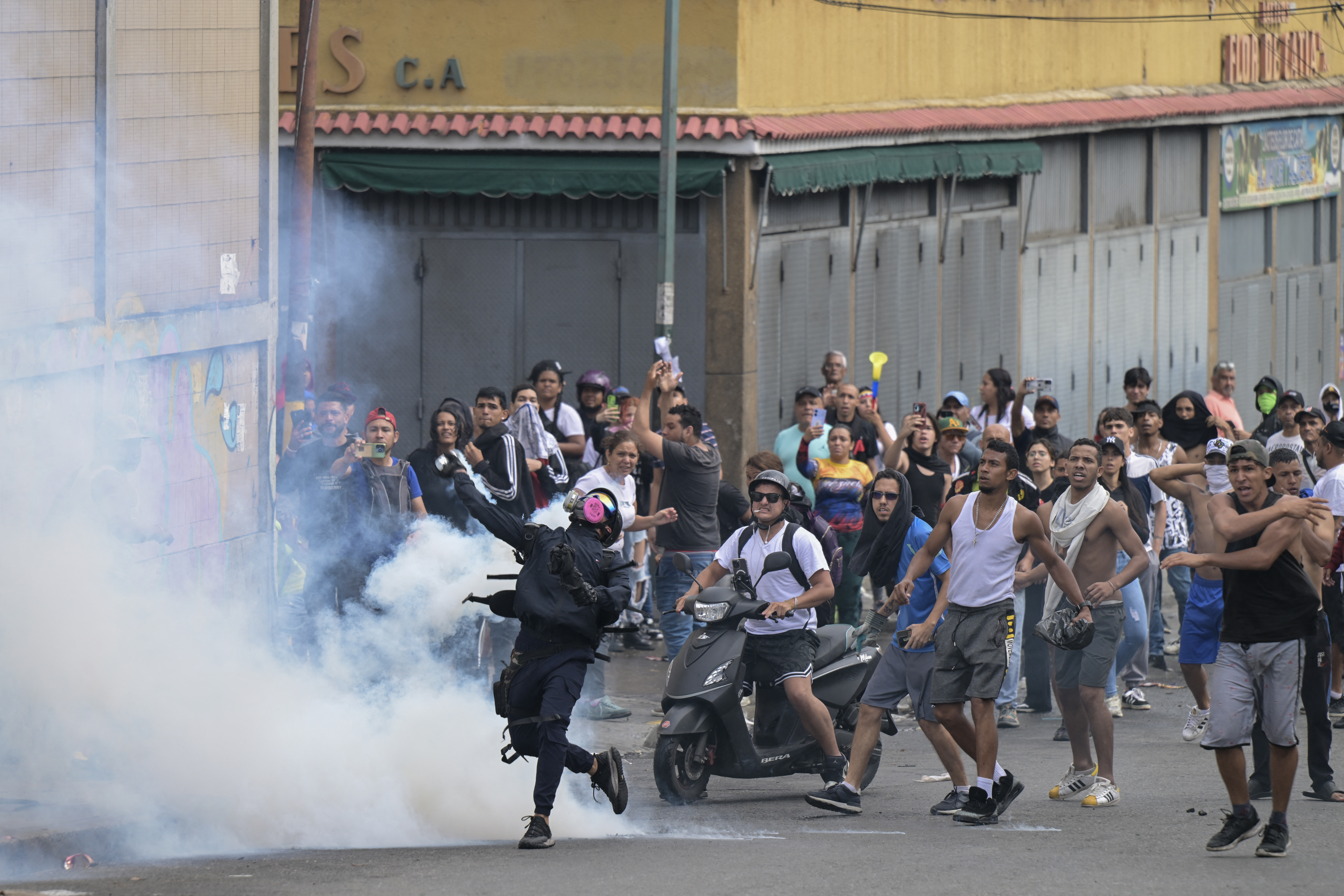 Opponents of Venezuelan President Nicolas Maduro's government clash with riot police during a protest in the Catia neighborhood of Caracas on July 29, 2024, a day after the Venezuelan presidential election. Protests erupted in parts of Caracas Monday against the re-election victory claimed by Venezuelan President Nicolas Maduro but disputed by the opposition and questioned internationally, AFP journalists observed. (Photo by Yuri CORTEZ / AFP)