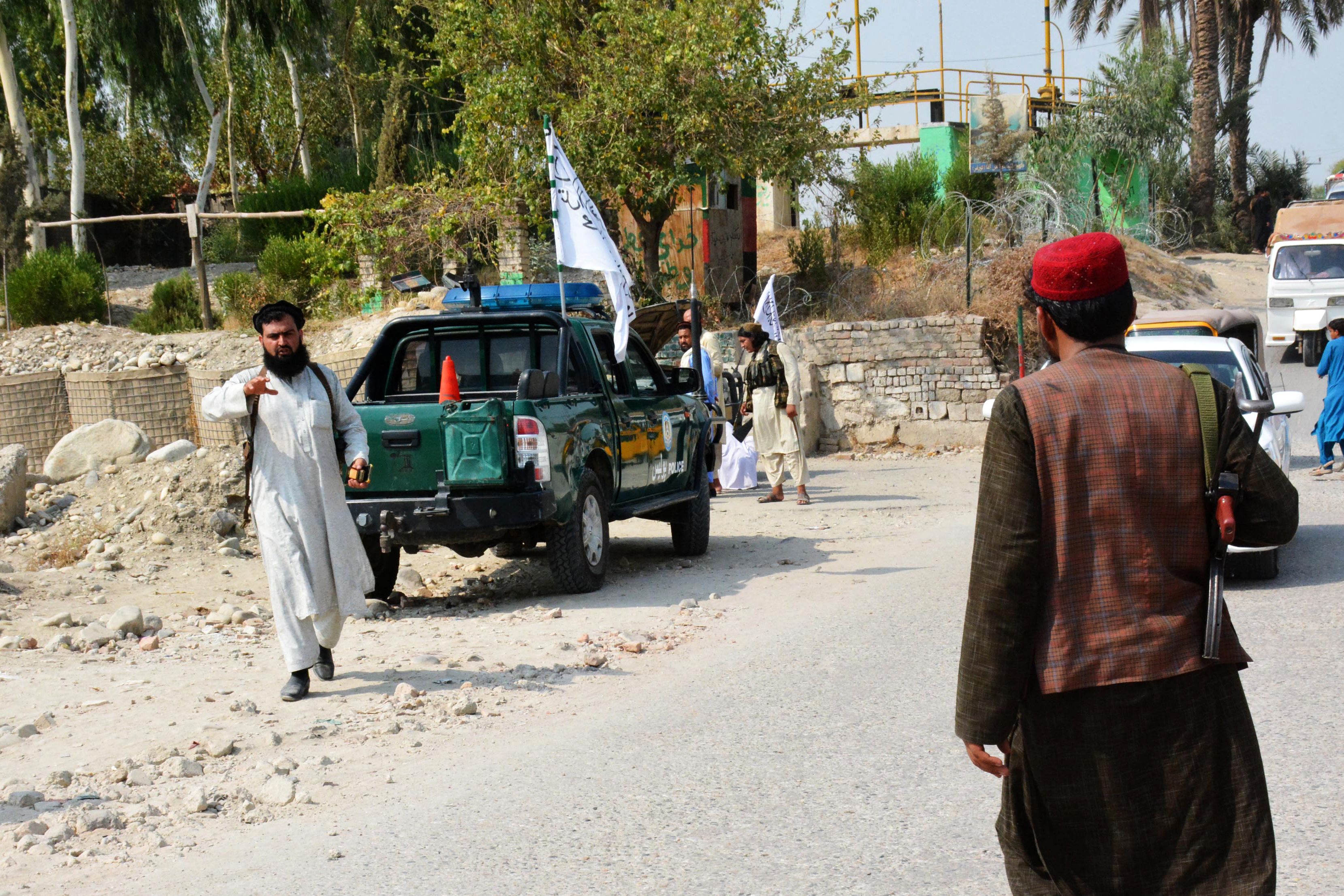 Taliban members inspect near the site of a blast in Jalalabad on September 18,2021. - At least two people were killed and 19 injured on September 18, 2021, in several bombings in Jalalabad, the major city in eastern Afghanistan, according to a hospital official and several local media. (Photo by STR / AFP)