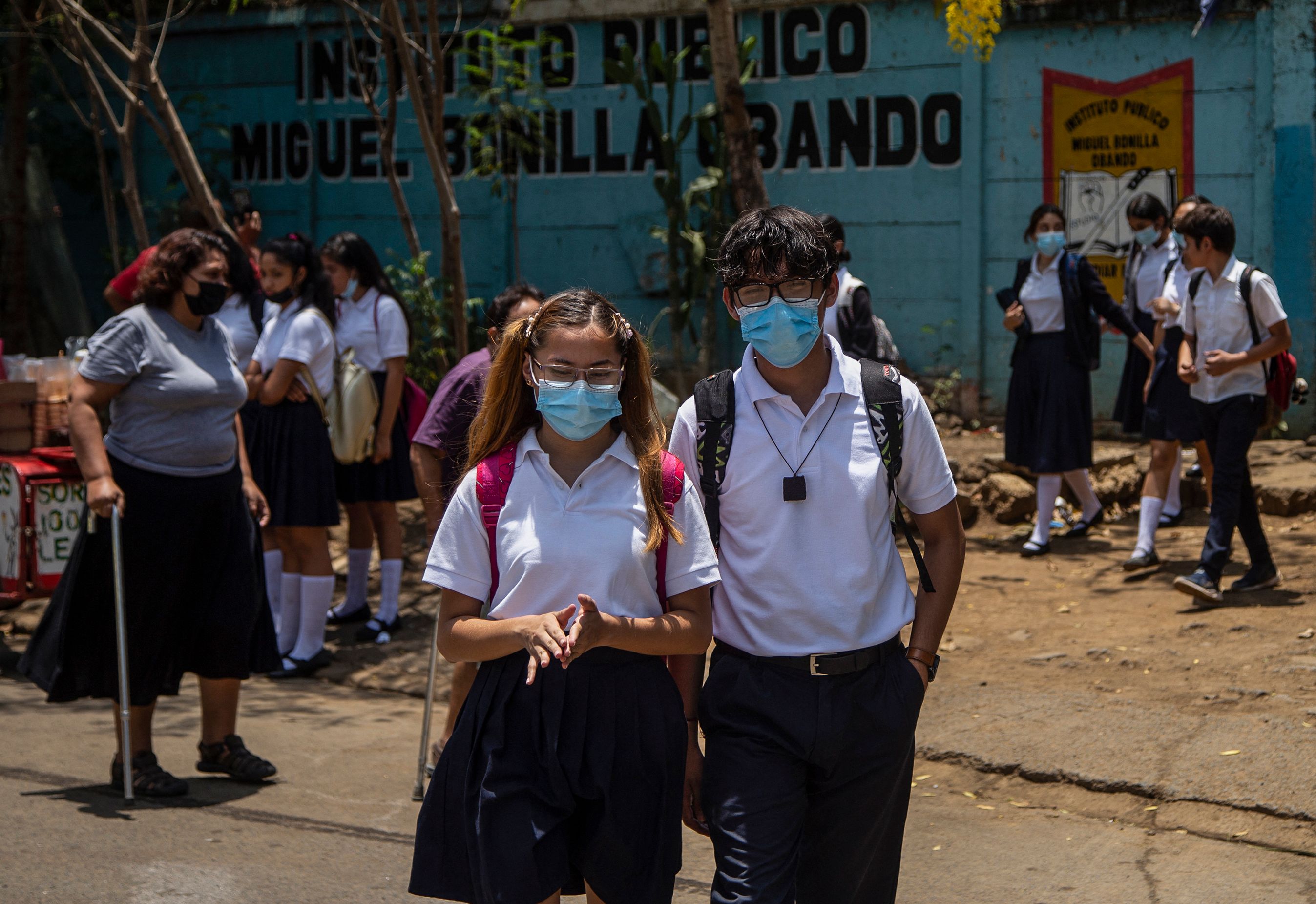 Students wearing face masks walk back to their homes from Miguel Bonilla Obando Public School in Managua, on April 29, 2021. - Several private schools in Nicaragua opted to suspend their on-site classes, amid an apparent upturn in cases of covid-19, which also affects public schools, in a country where no major pandemic containment measures were adopted. (Photo by INTI OCON / AFP)