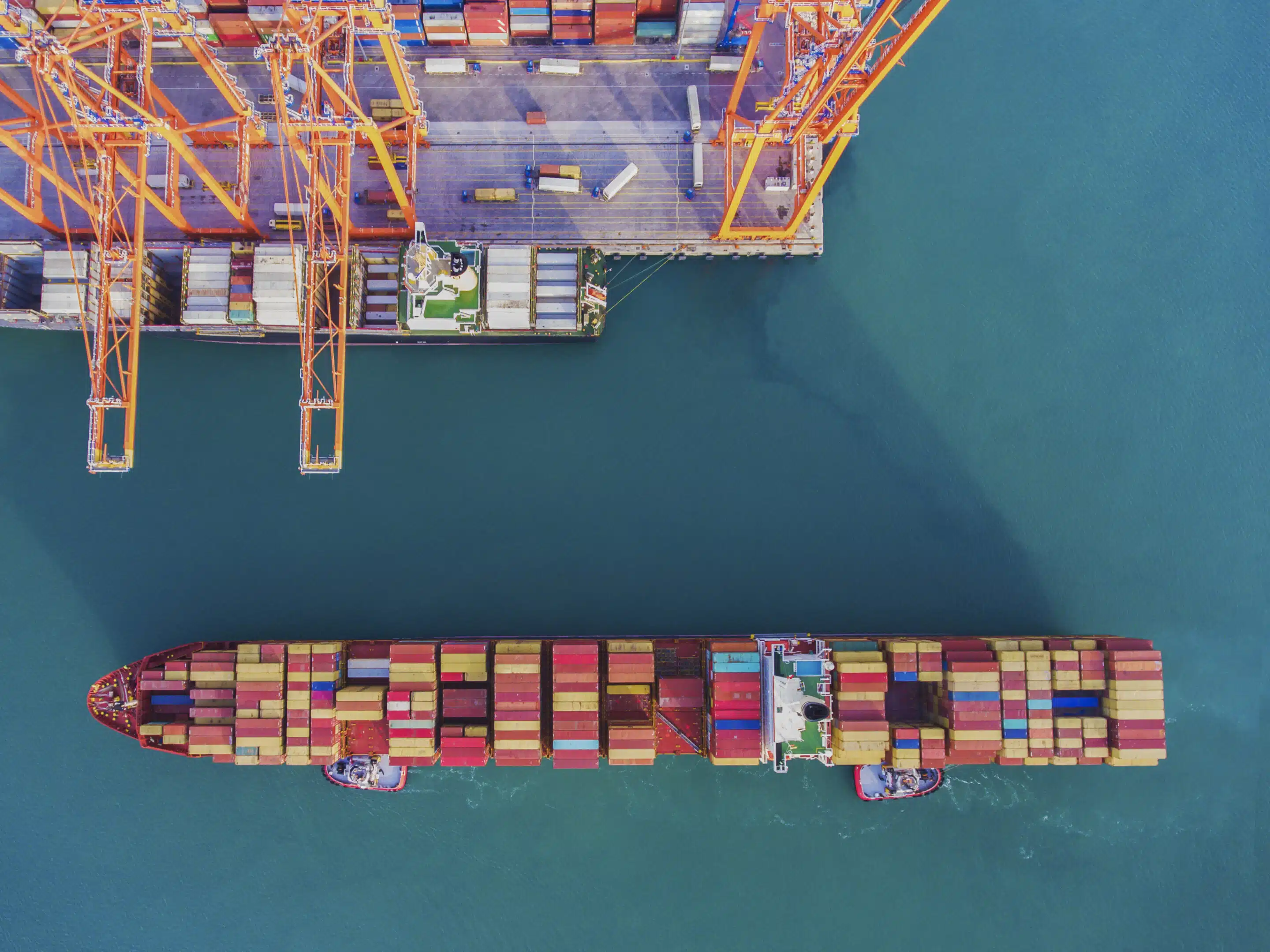 Gran buque de transporte y vista de puerto. Vista aérea de la terminal de contenedores con grúa de carga.