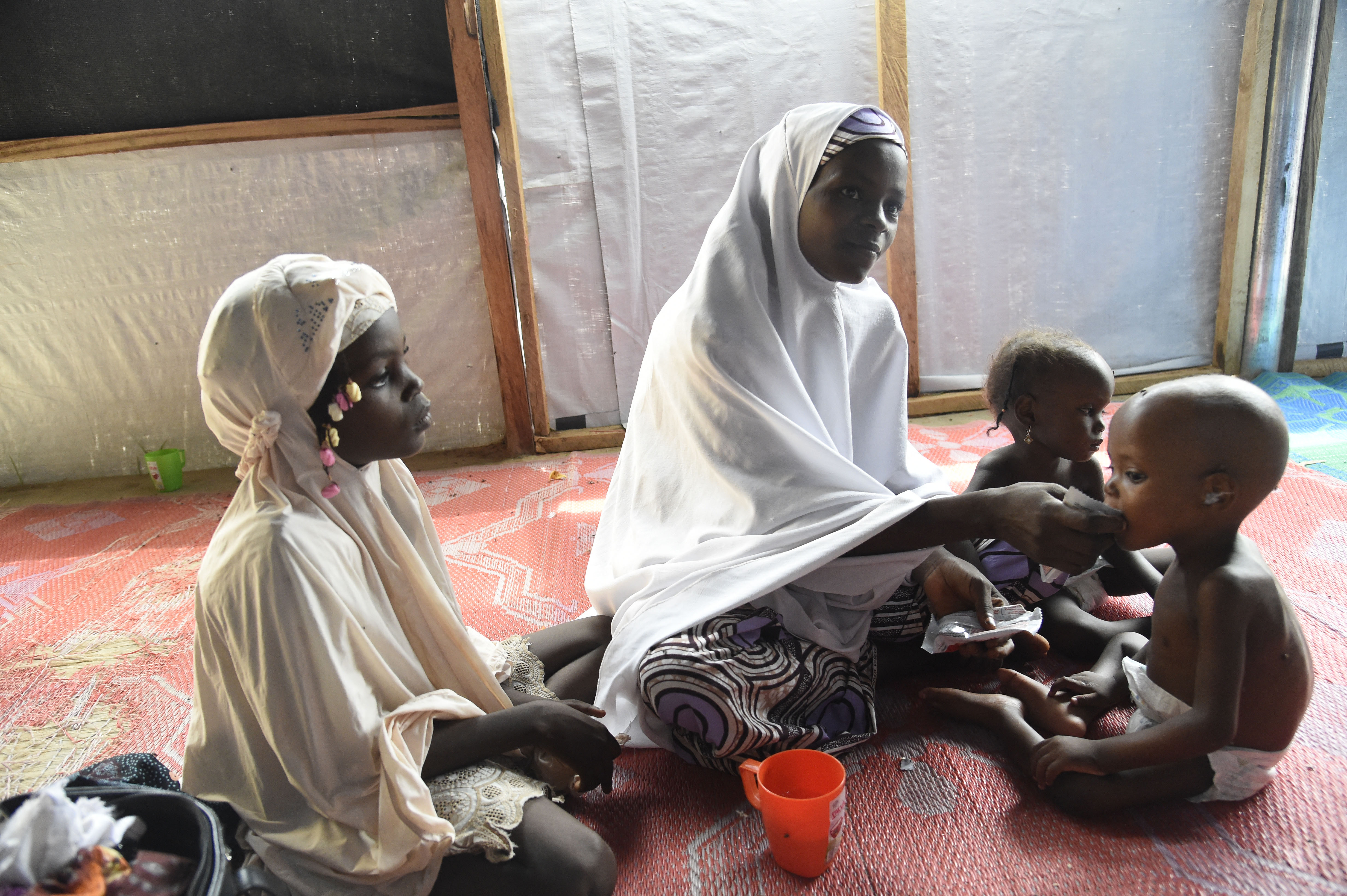 A mother feeds child suffering malnutrition in a clinic set up by health authorities with Medecins Sans Frontieres or Doctors Without Borders (MSF)in Katsina State, northwest Nigeria, on July 20, 2022. - Rural northwest Nigeria has been ravaged by gangs of bandit militias who raid villages, loot cattle and kidnap people to hold them for ransom in camps deep in the forests that carpet large swaths of the region.
Hundreds of thousands have been displaced across the northwest and central regions, and thousands killed in violence rivalling the impact of the 13-year jihadist conflict that has killed more than 40,000 people. (Photo by PIUS UTOMI EKPEI / AFP)