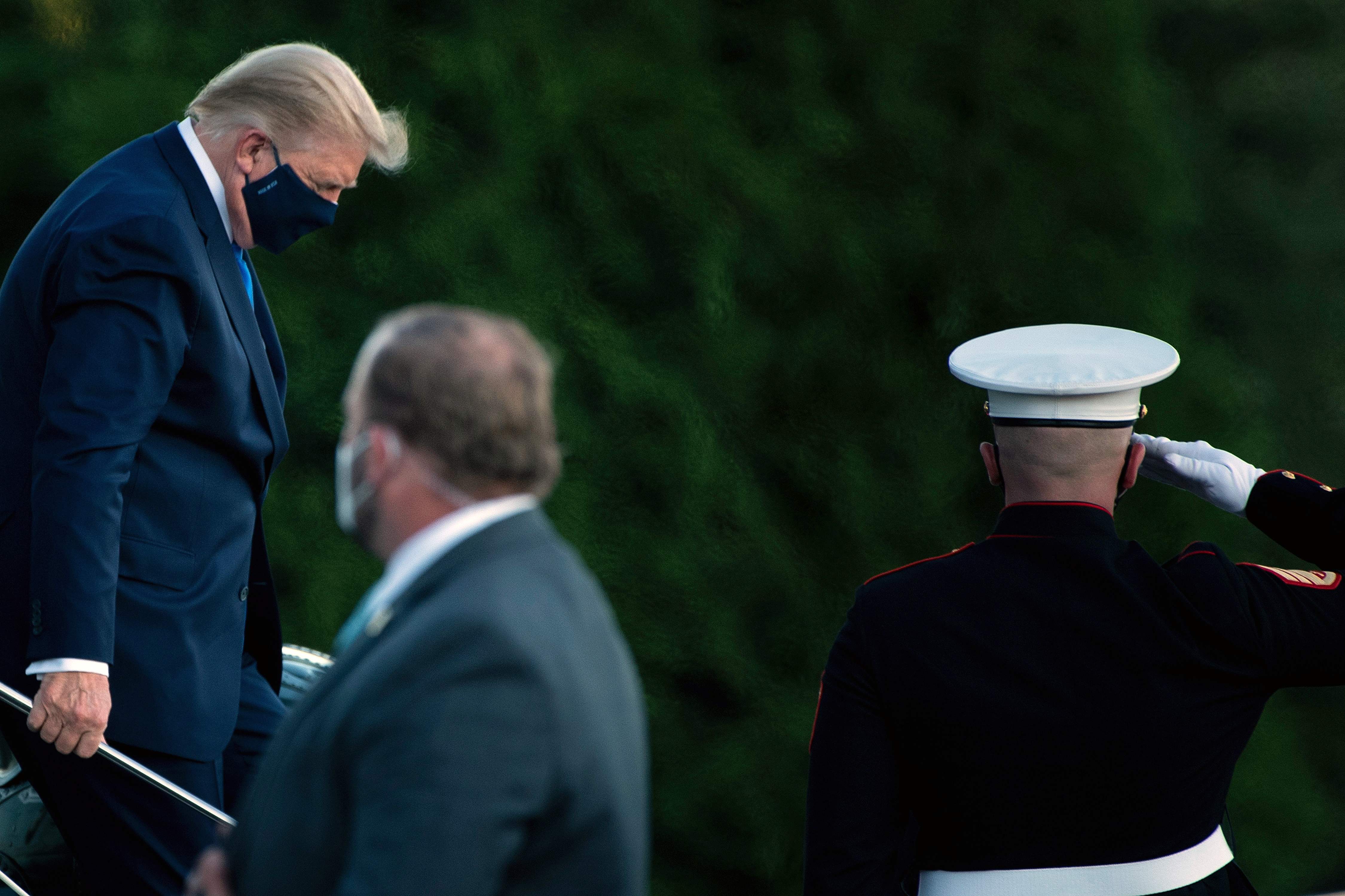US President Donald Trump walks off Marine One while arriving at Walter Reed Medical Center in Bethesda, Maryland on October 2, 2020, after testing positive for covid-19. - President Donald Trump will spend the coming days in a military hospital just outside Washington to undergo treatment for the coronavirus, but will continue to work, the White House said Friday (Photo by Brendan Smialowski / AFP)