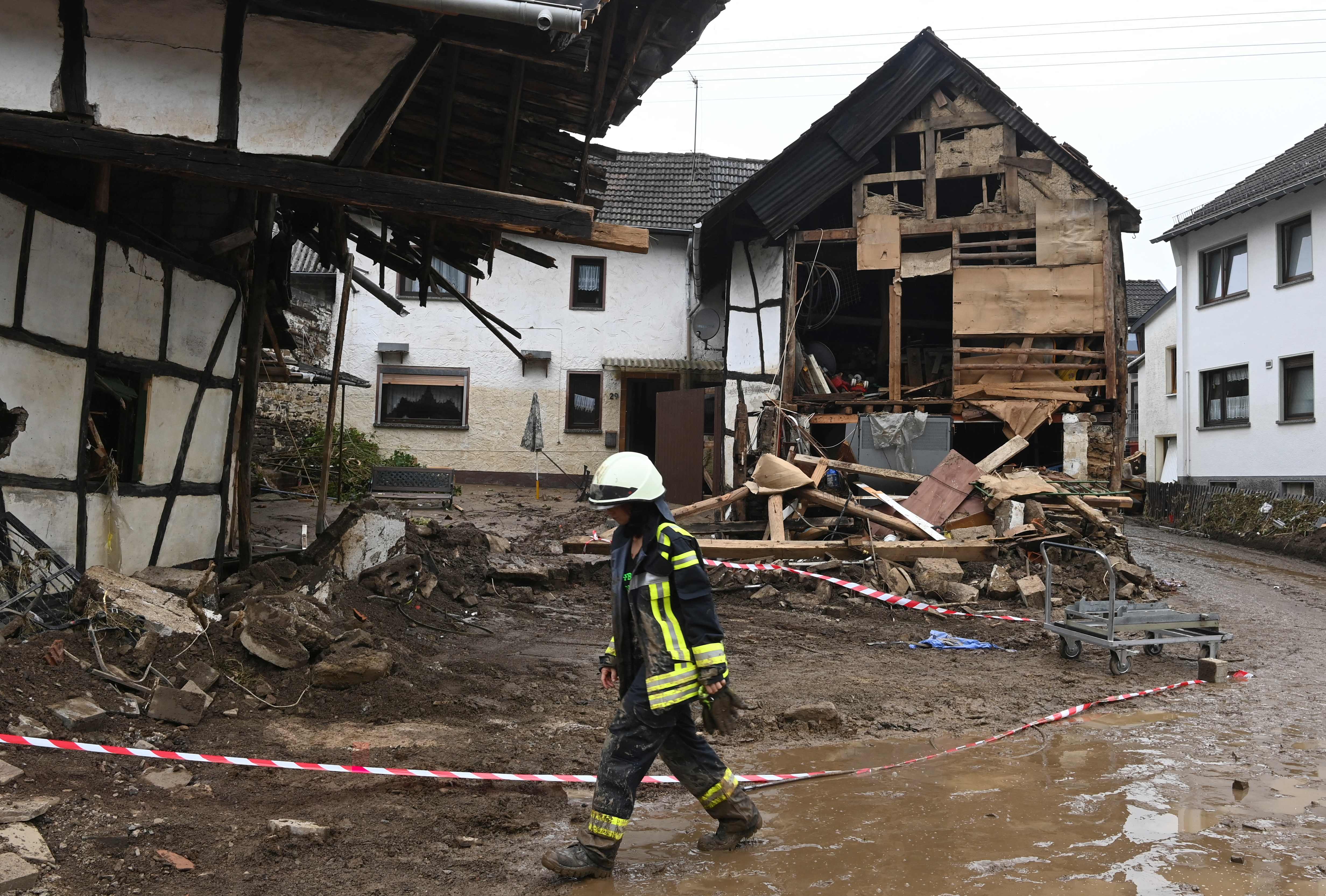 A firefighter walks past severely damaged ancient houses after the floods caused major damage in Schuld near Bad Neuenahr-Ahrweiler, western Germany, on July 17, 2021. - Devastating floods in Germany and other parts of western Europe have been described as a "catastrophe", a "war zone" and "unprecedented", with more than 150 people dead and the toll still climbing on July 17, 2021 (Photo by CHRISTOF STACHE / AFP)