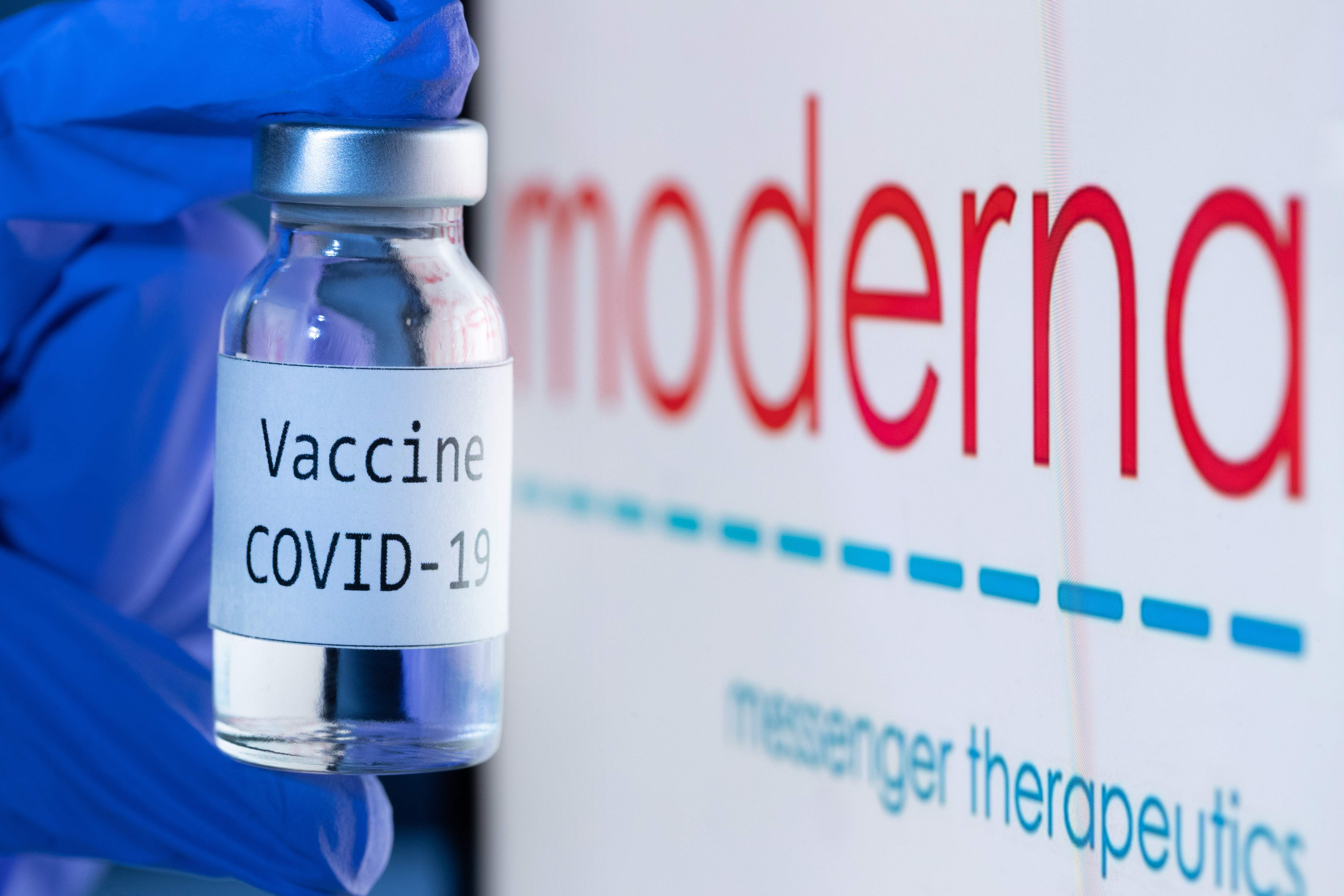 (FILES) In this file photo taken on November 18, 2020 shows a bottle reading "Vaccine Covid-19" next to the Moderna biotech company logo. - American experts were set to discuss on December 17, 2020 if Moderna's Covid-19 vaccine should be authorized, as European nations vowed to get their coronavirus inoculation campaigns rolling before the end of the year. Surges in infections have prompted tighter restrictions in several European countries, while the United States -- the worst-hit nation in the world -- set a double record, with more than 3,700 deaths and 250,000 new cases in 24 hours on December 16, 2020. (Photo by JOEL SAGET / AFP) / -- IMAGE RESTRICTED TO EDITORIAL USE - STRICTLY NO COMMERCIAL USE --