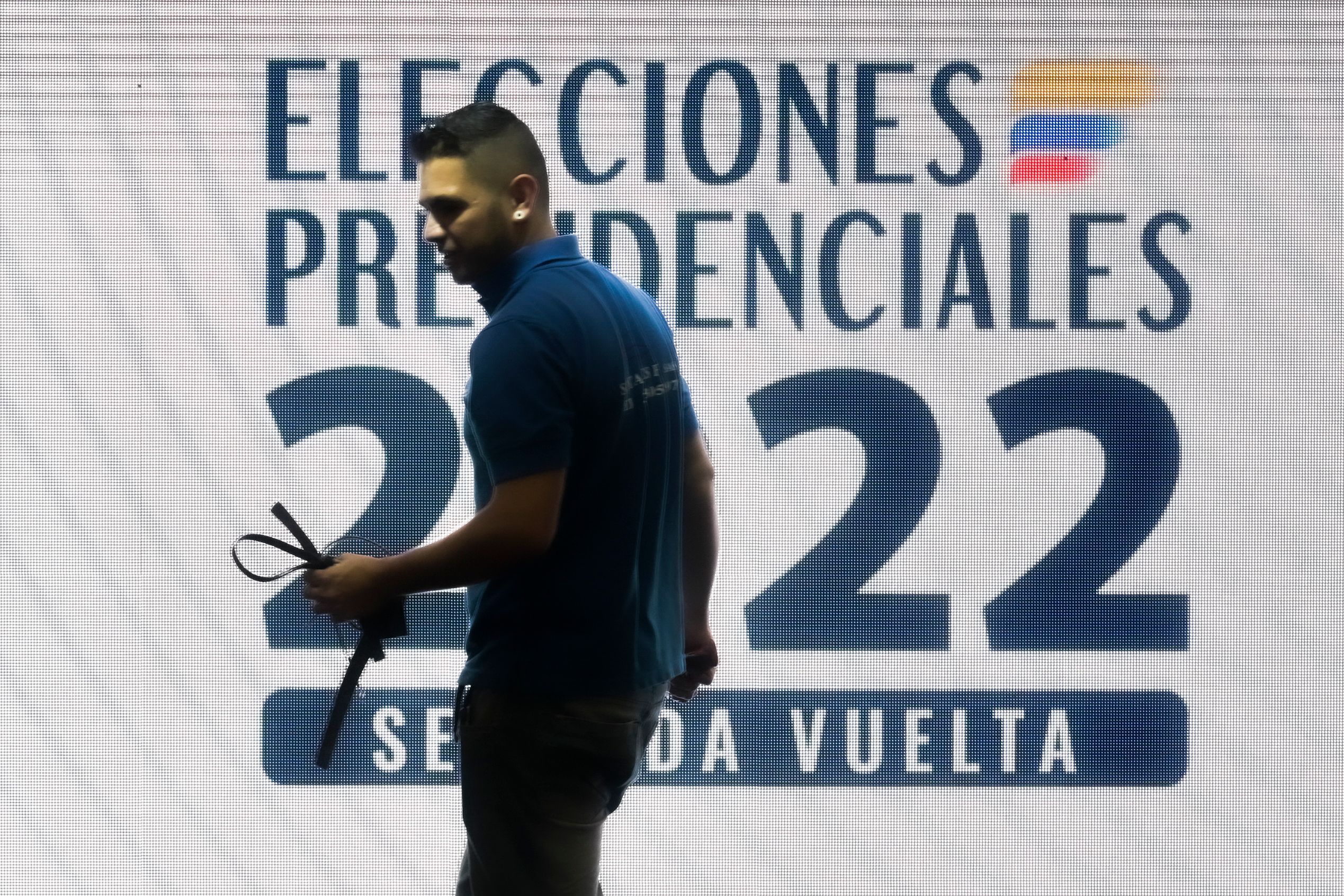 A man works at a polling station in Bogota, on June 18, 2022, a day before the presidential runoff election. - Colombians vote Sunday in a presidential runoff that features promises of radical change in a country saddled with widespread poverty, violence and other woes. After a tense campaign marked by claims of death threats against several candidates, opinion polls have leftist Gustavo Petro and businessman Rodolfo Hernandez neck-and-neck. (Photo by Juan BARRETO / AFP)