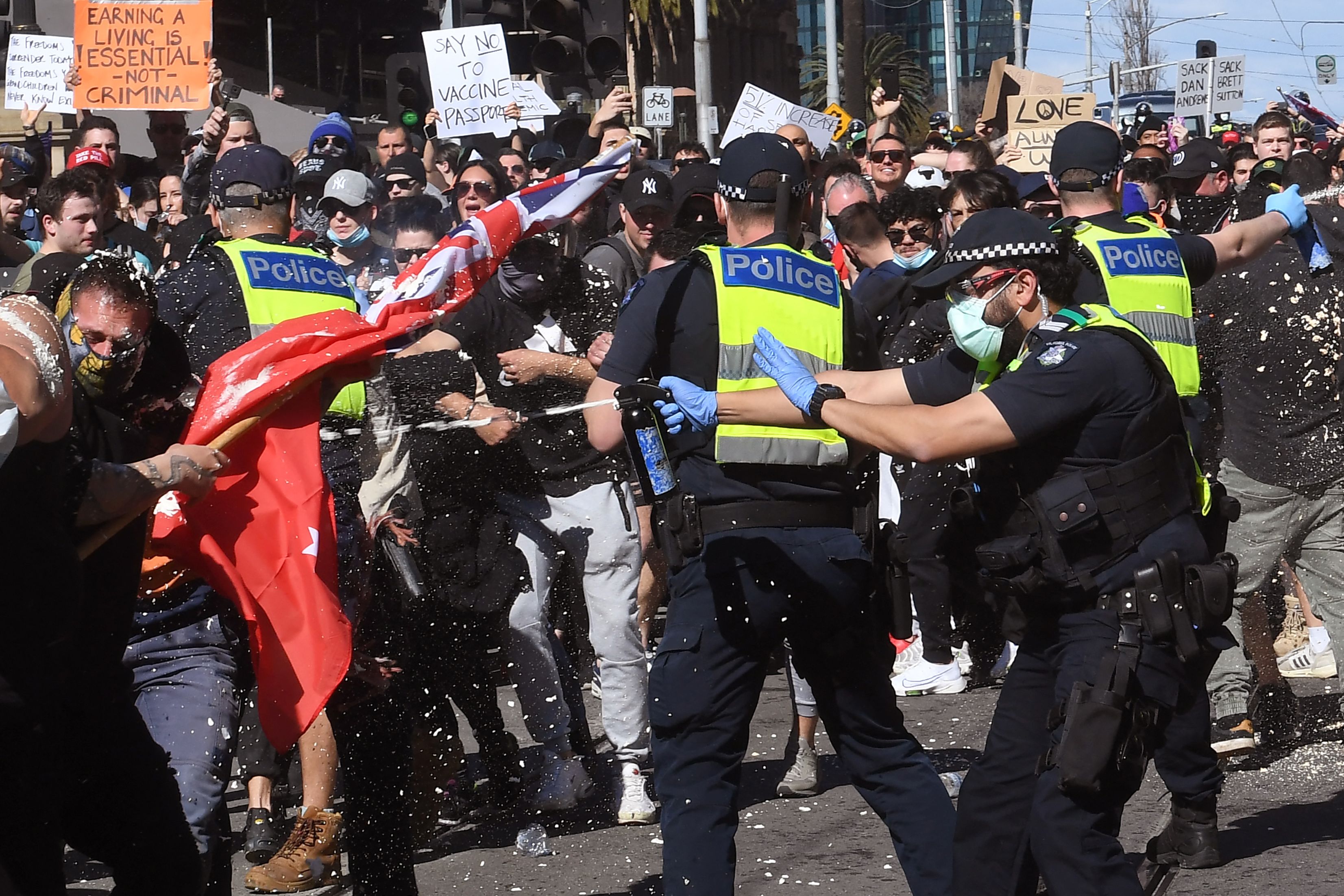 Police pepper spray protesters during an anti-lockdown rally in Melbourne on August 21, 2021, amid the city's sixth lockdown to contain a coronavirus outbreak. (Photo by William WEST / AFP)
